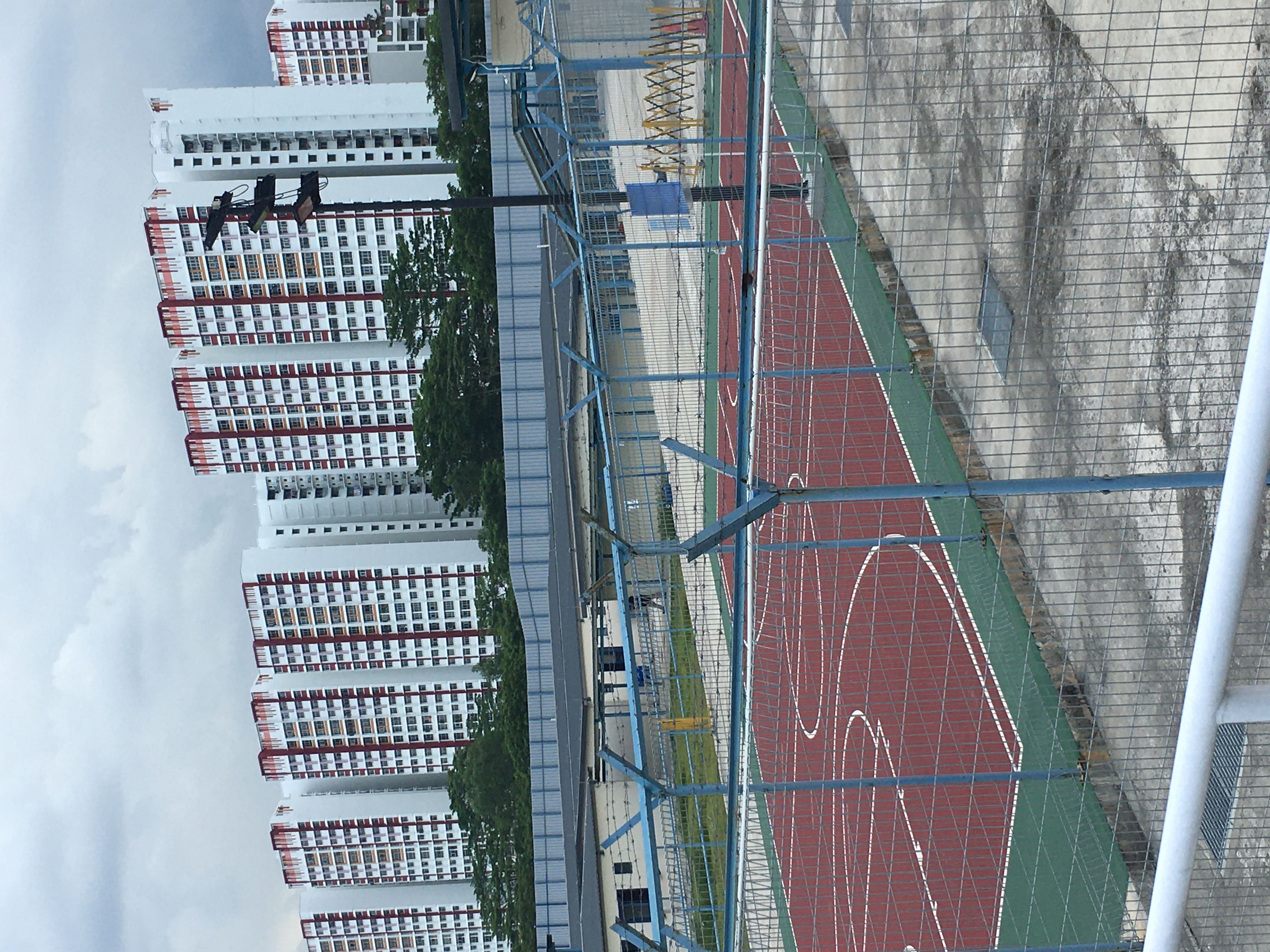 A basketball court for workers is surrounded by barbed wire fencing in their compoound in a northwestern part of Singapore