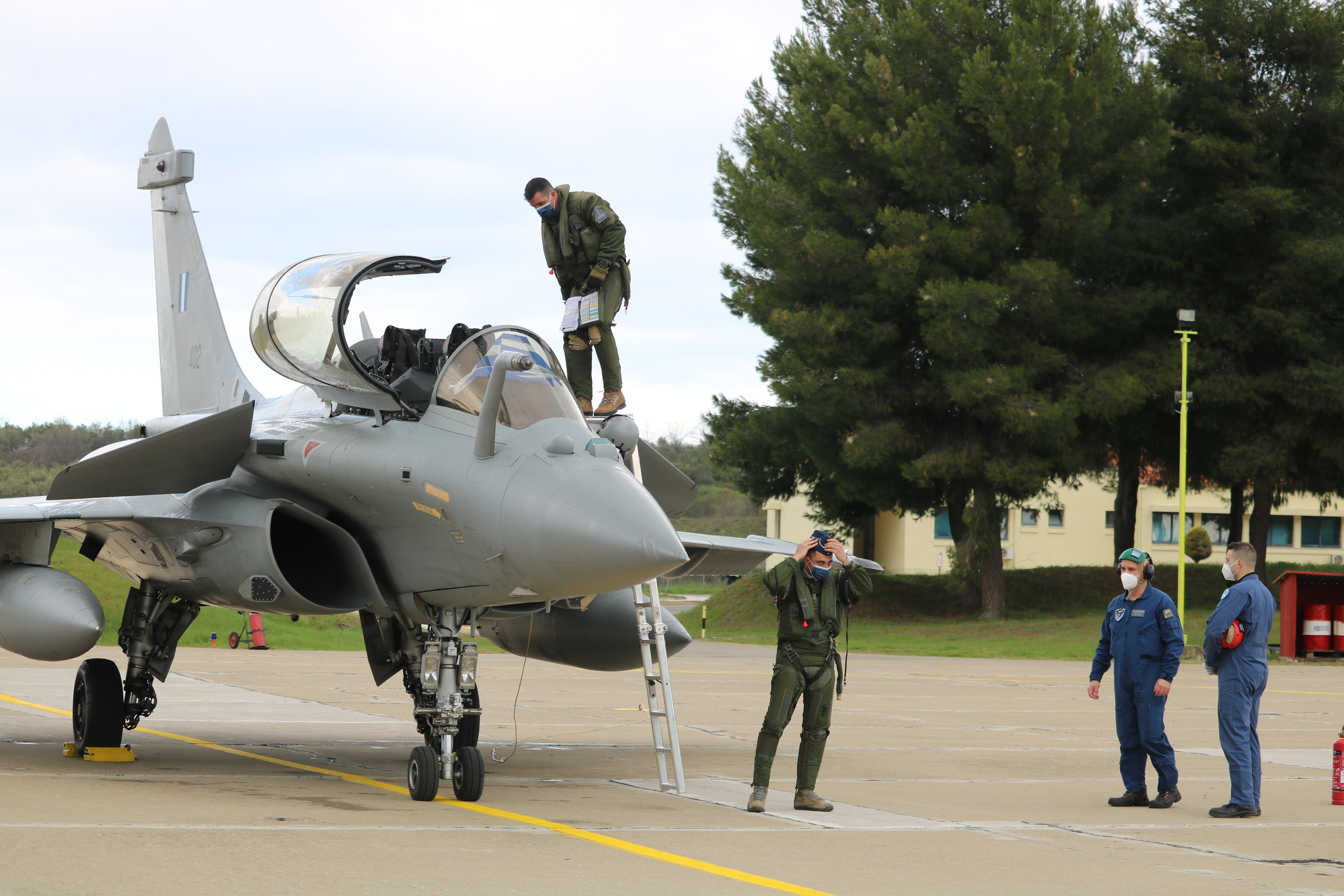 A pilot climbs out of the cockpit of a two-seater Rafale