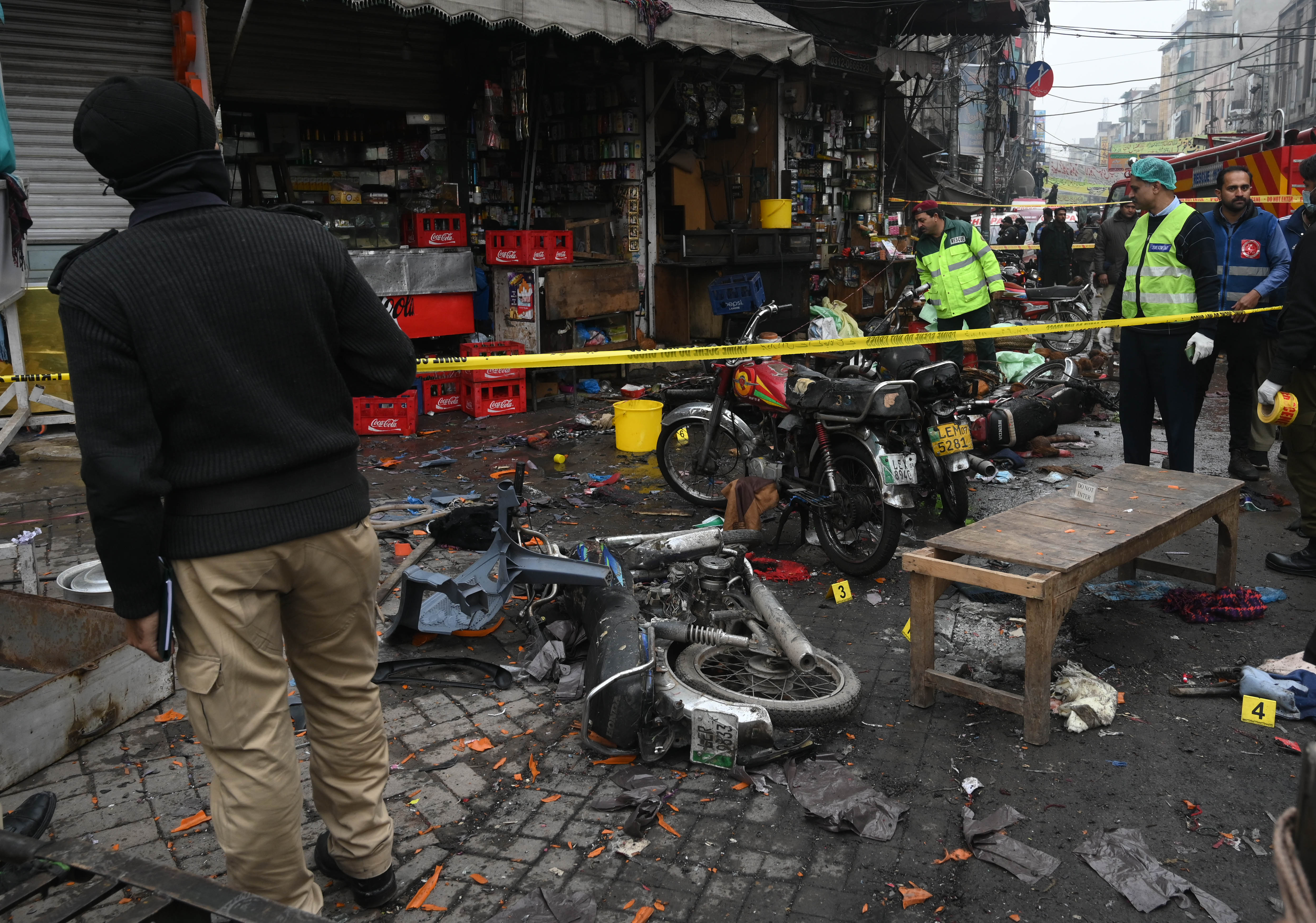 Pakistani security officials inspect the scene of a bomb blast in Lahore, Pakistan, 20 January 2022. According to police and health officials, At least 3 people were killed and more than 20 were injured when a bomb exploded in a famous shopping market Anarkali in country's cultural hub, Lahore. 