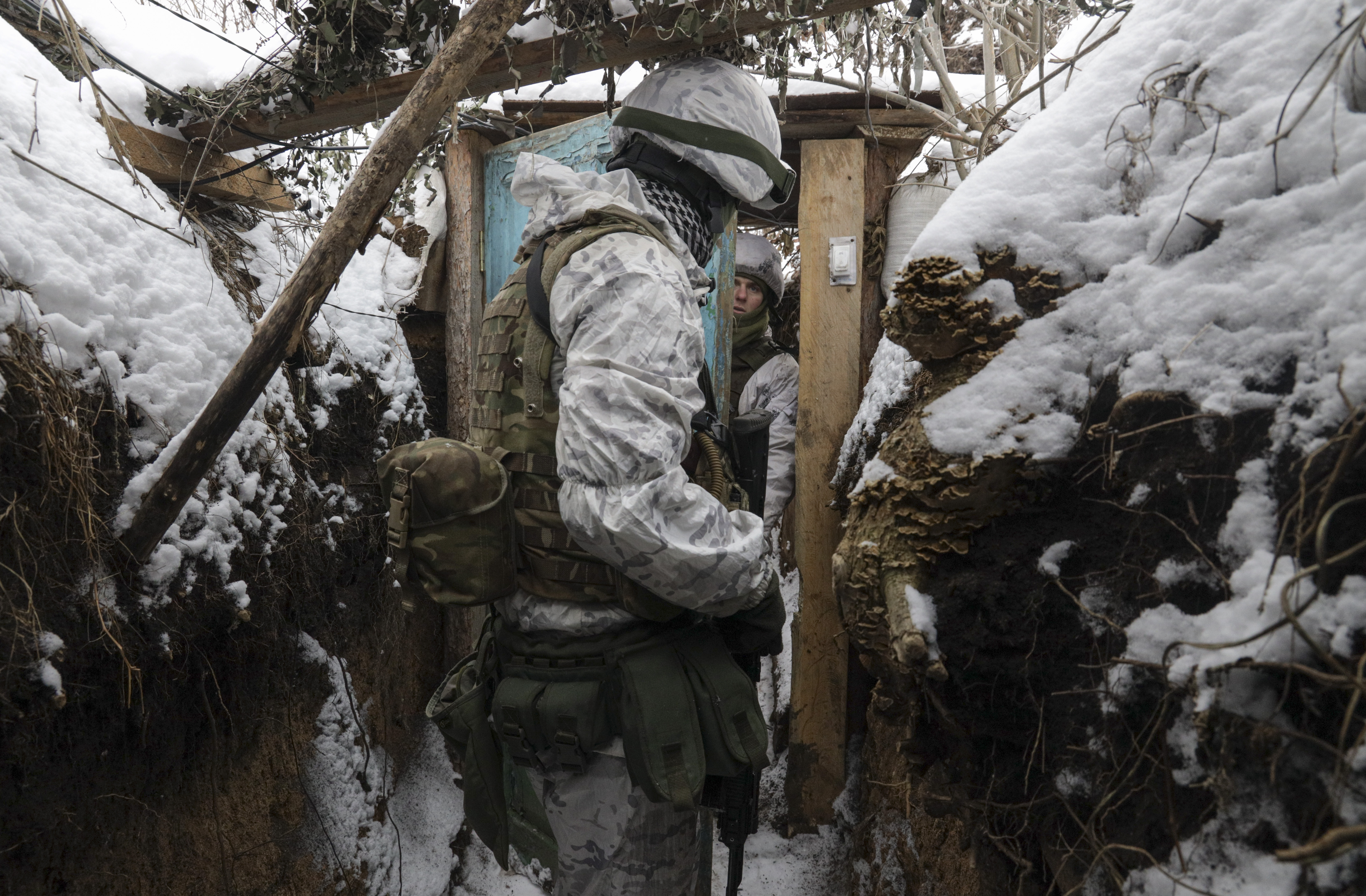 Ukrainian servicemen check the situation at the positions on a front line near the Avdiivka village