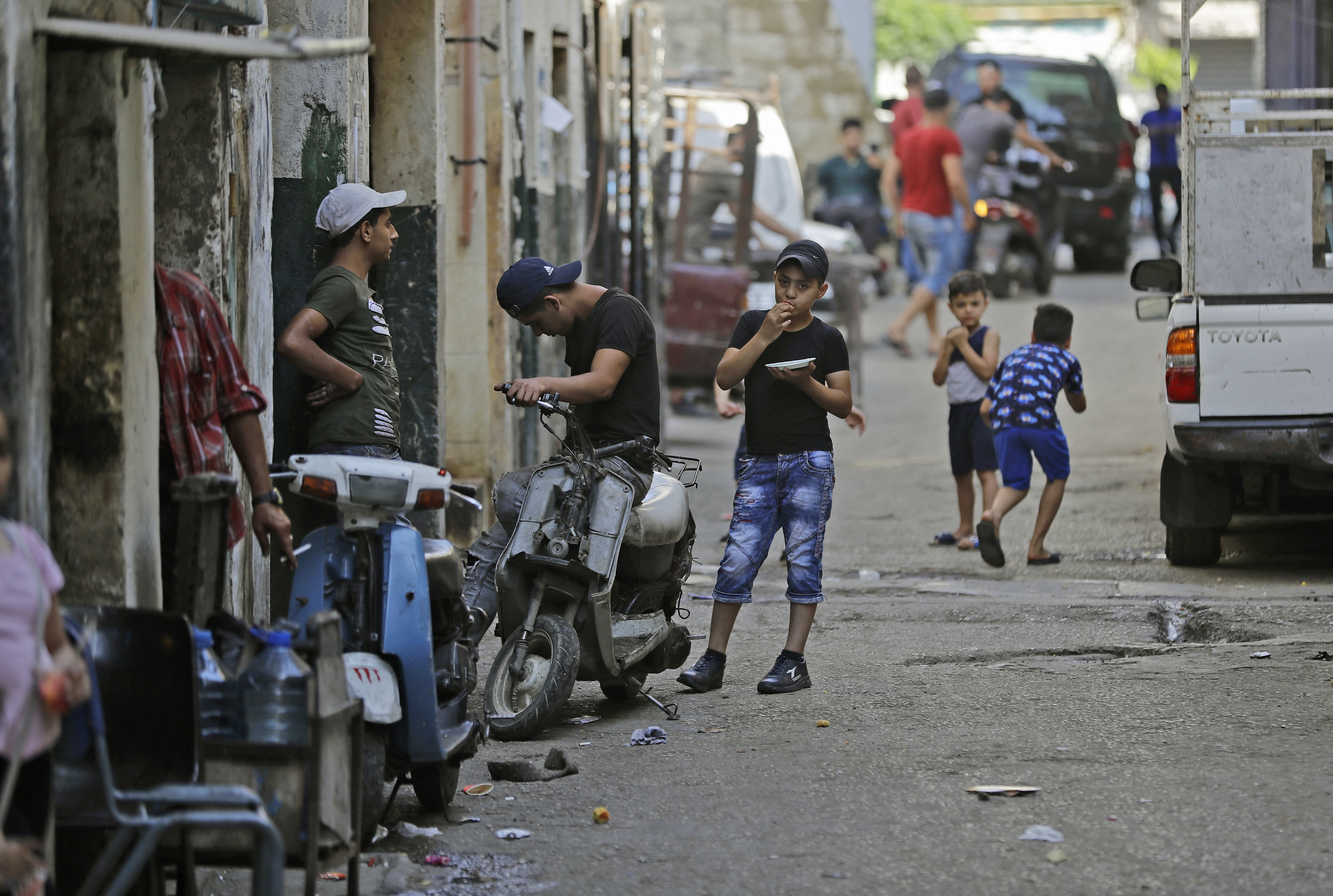 A boy sits atop a scooter along an alley in the Bab al-Tabbaneh, Tripoli.
