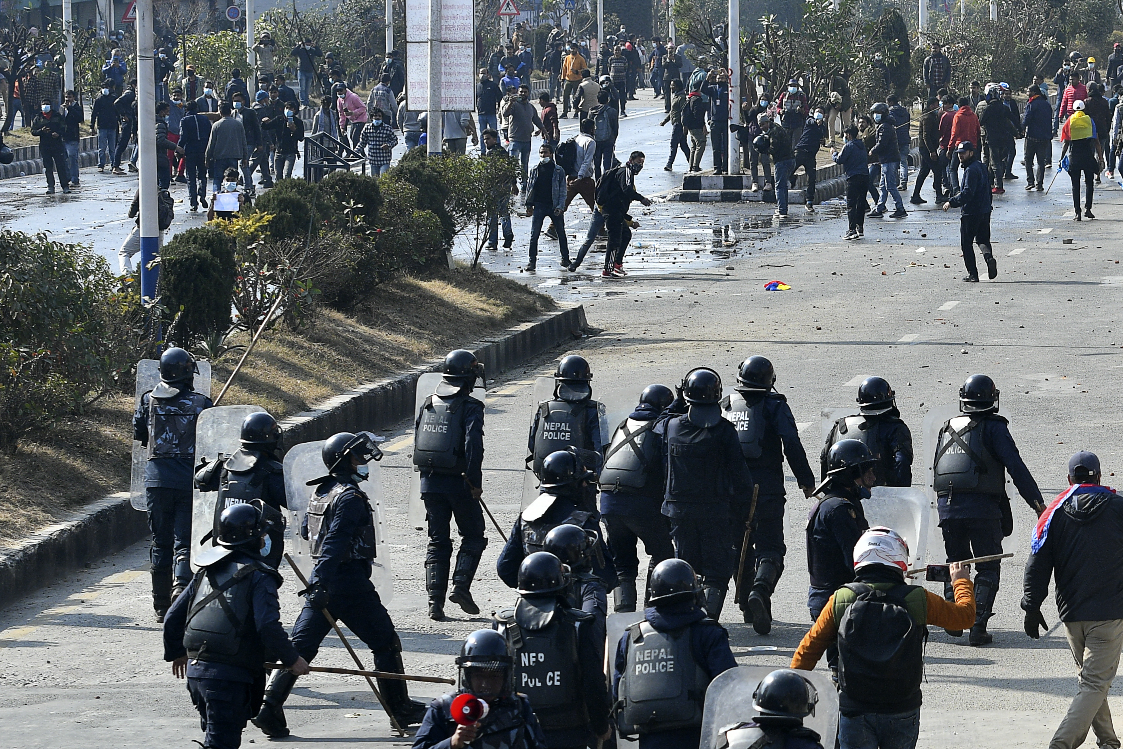 Demonstrators throw stones at a police during a protest against the proposed grant agreement from America