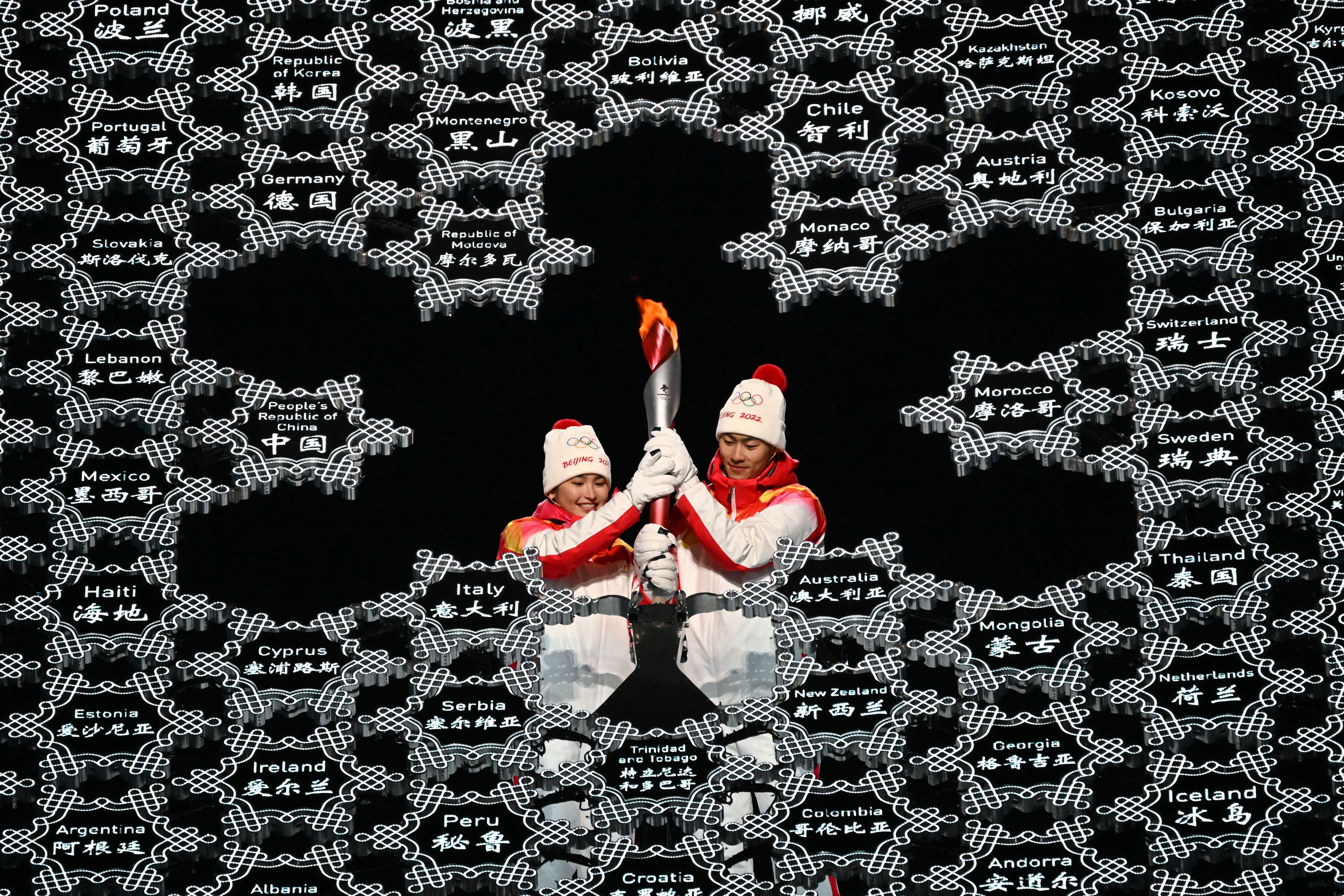 Chinese torchbearer athletes Dinigeer Yilamujian (L) and Zhao Jiawen hold the Olympic flame