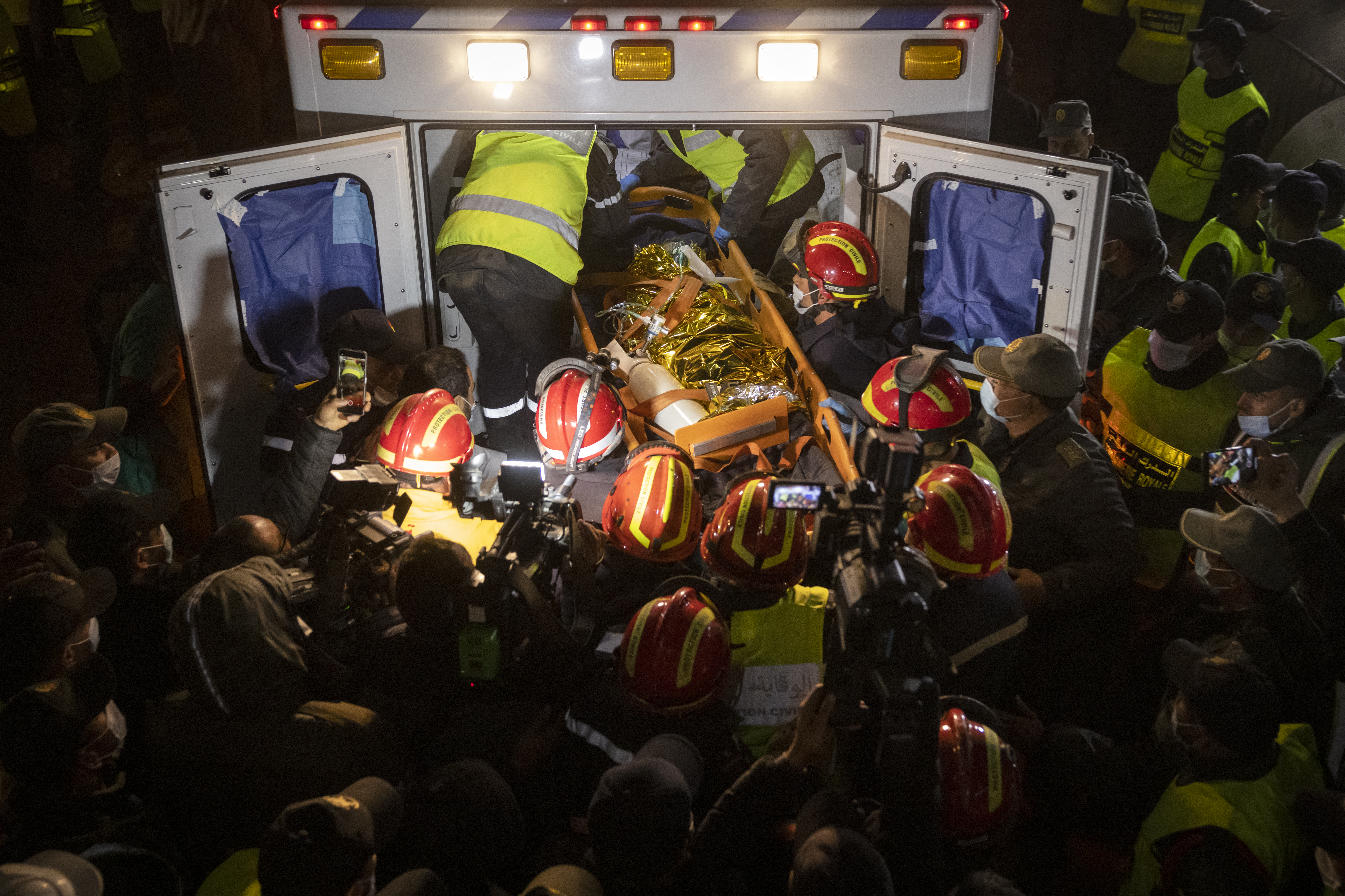 Moroccan emergency services teams carry five-year-old Rayan Oram into an ambulance