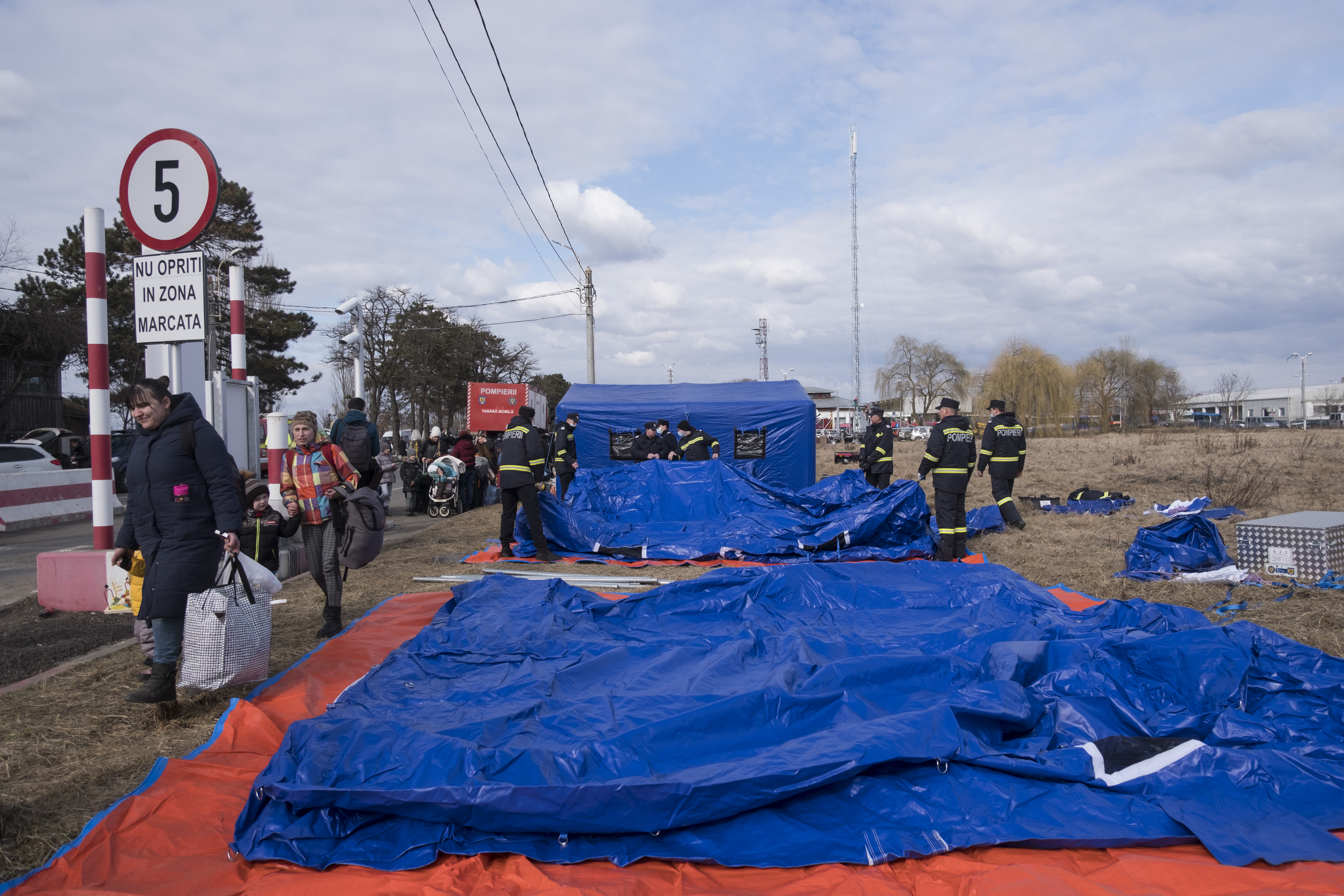 Romanian firefighters are building tents at the Siret border crossing to provide temporary shelter for the refugees waiting for transportation to other parts of the country.