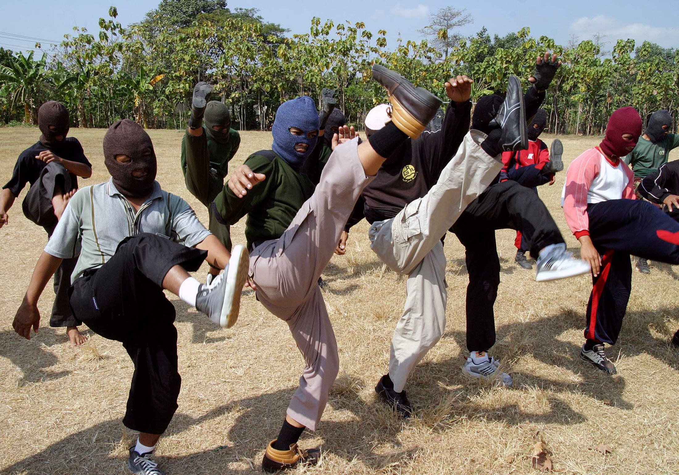 Members of Indonesia's hardline MMI kicking their legs as part of a set of exercises