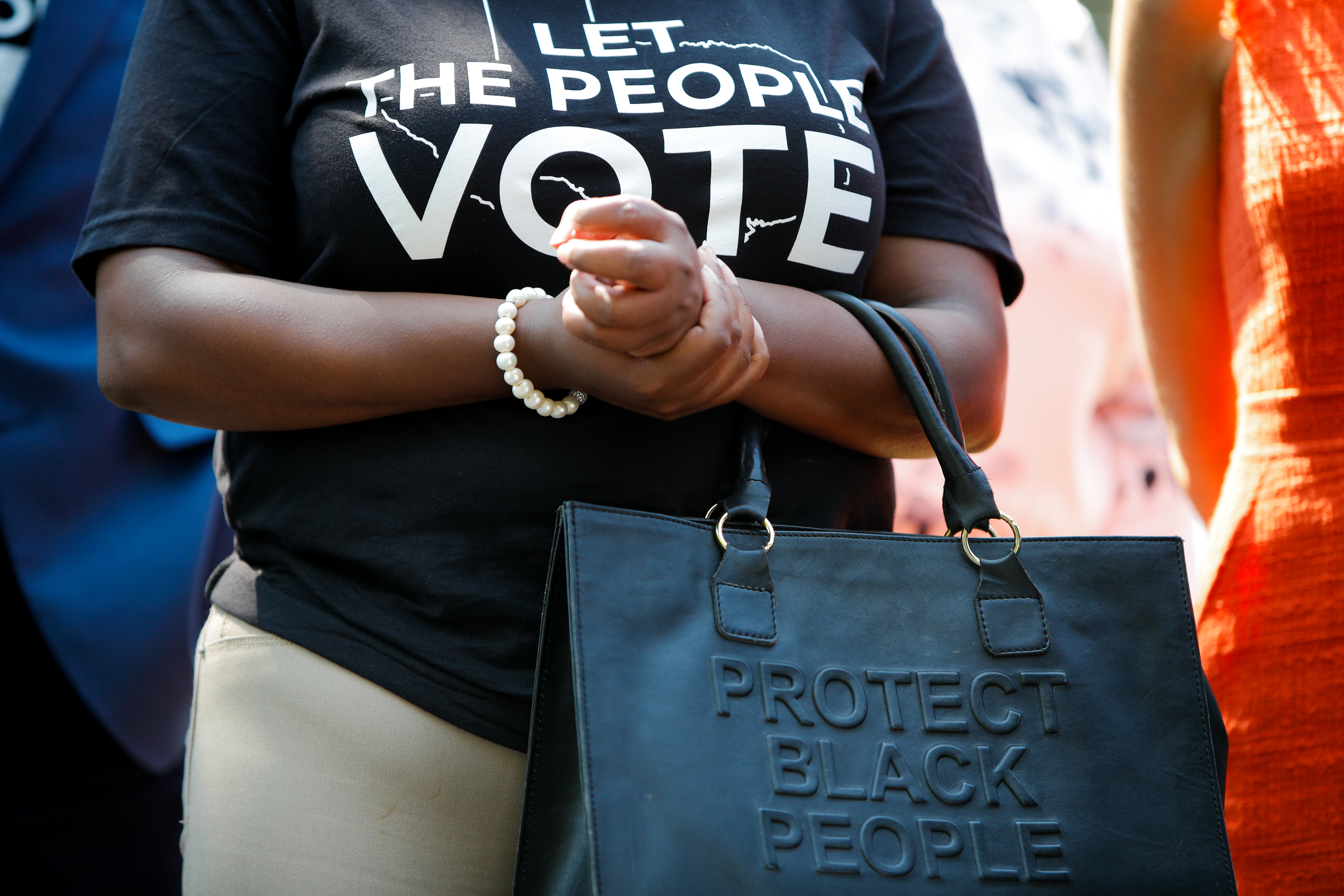 Texas House Representative Jasmine Crockett holds her purse during a news conference with Texas Democratic state lawmakers to discuss voting rights, on Capitol Hill.