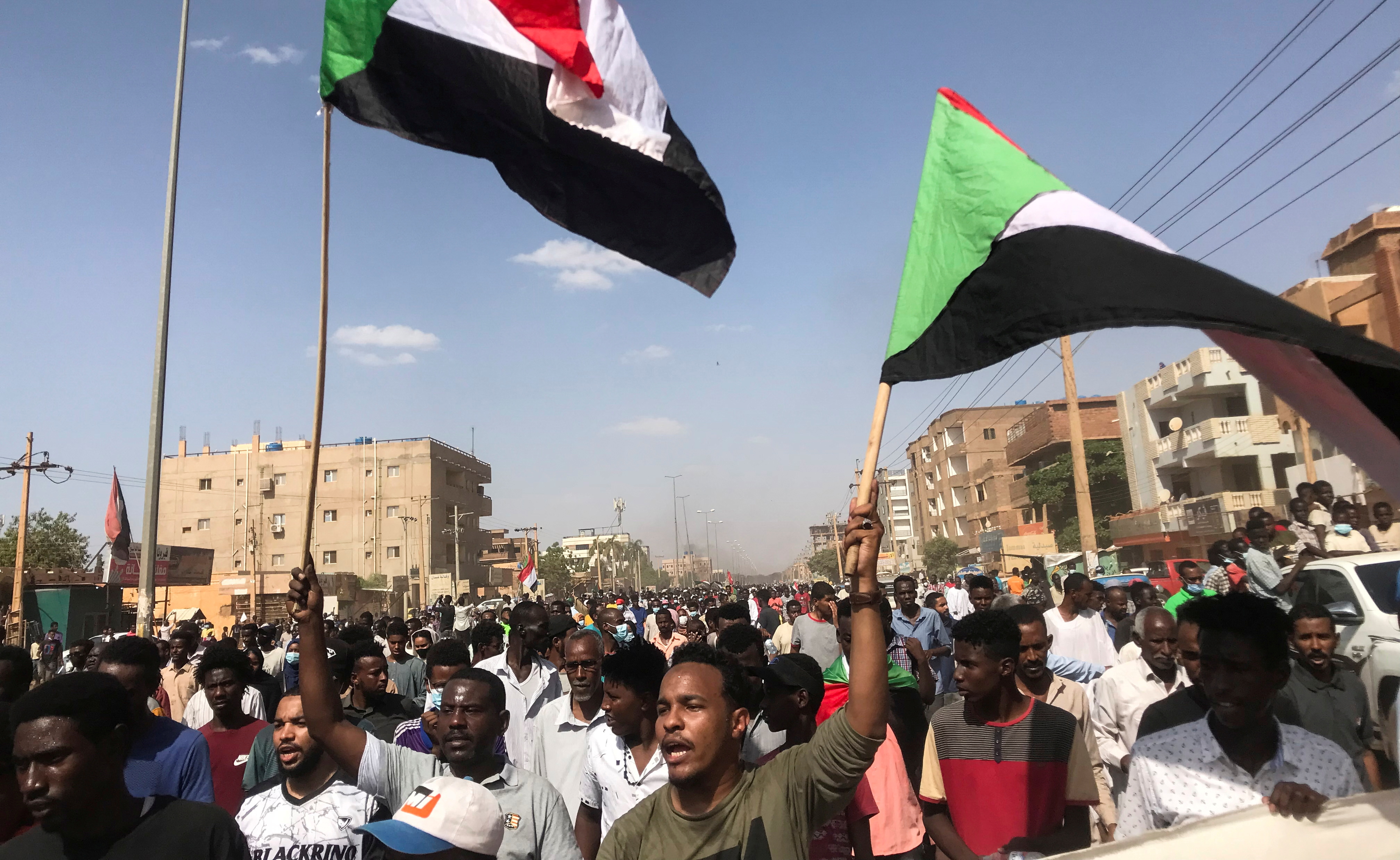 Protesters hold flags and chant slogans as they march against the Sudanese military government, in the streets of Khartoum. [File: Mohamed Nureldin/Reuters]