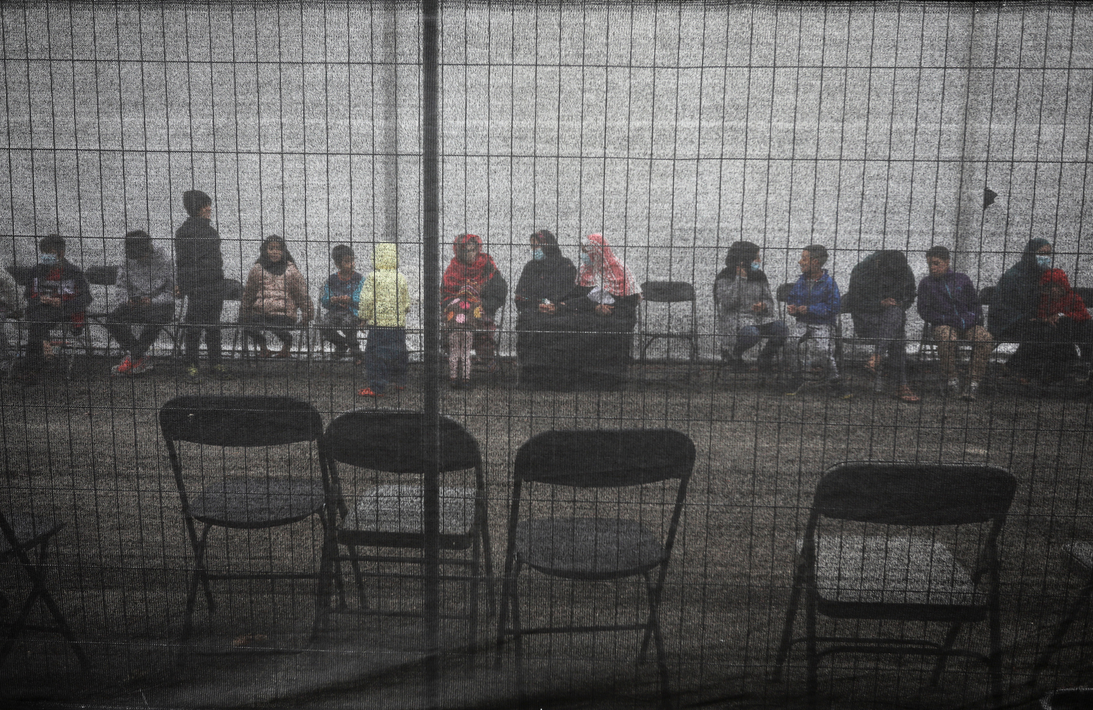 Afghan refugees queueing outside a distribution and donation center