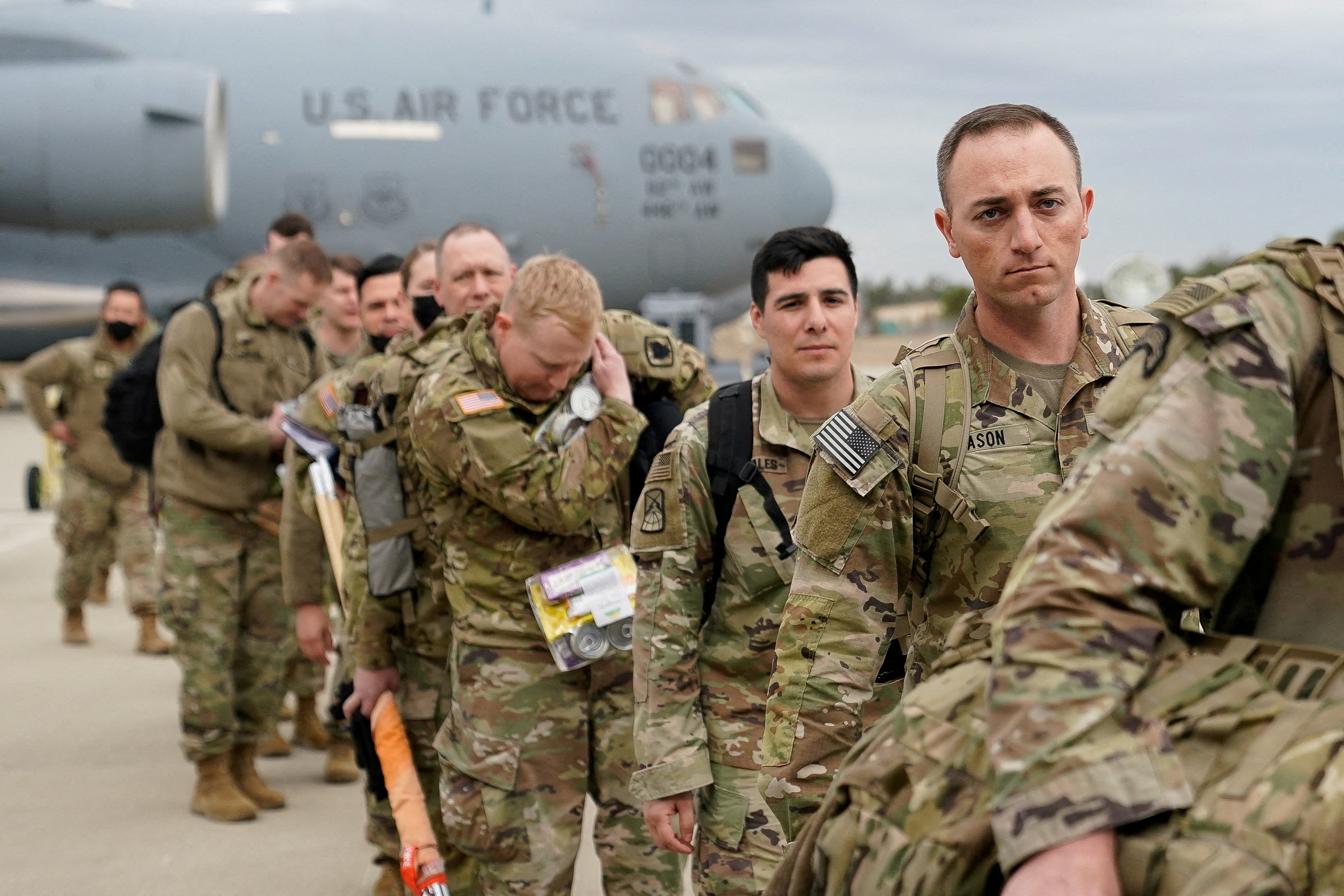 Military personnel from the 82nd Airborne Division and 18th Airborne Corps board a C-17 transport plane for deployment to Eastern Europe