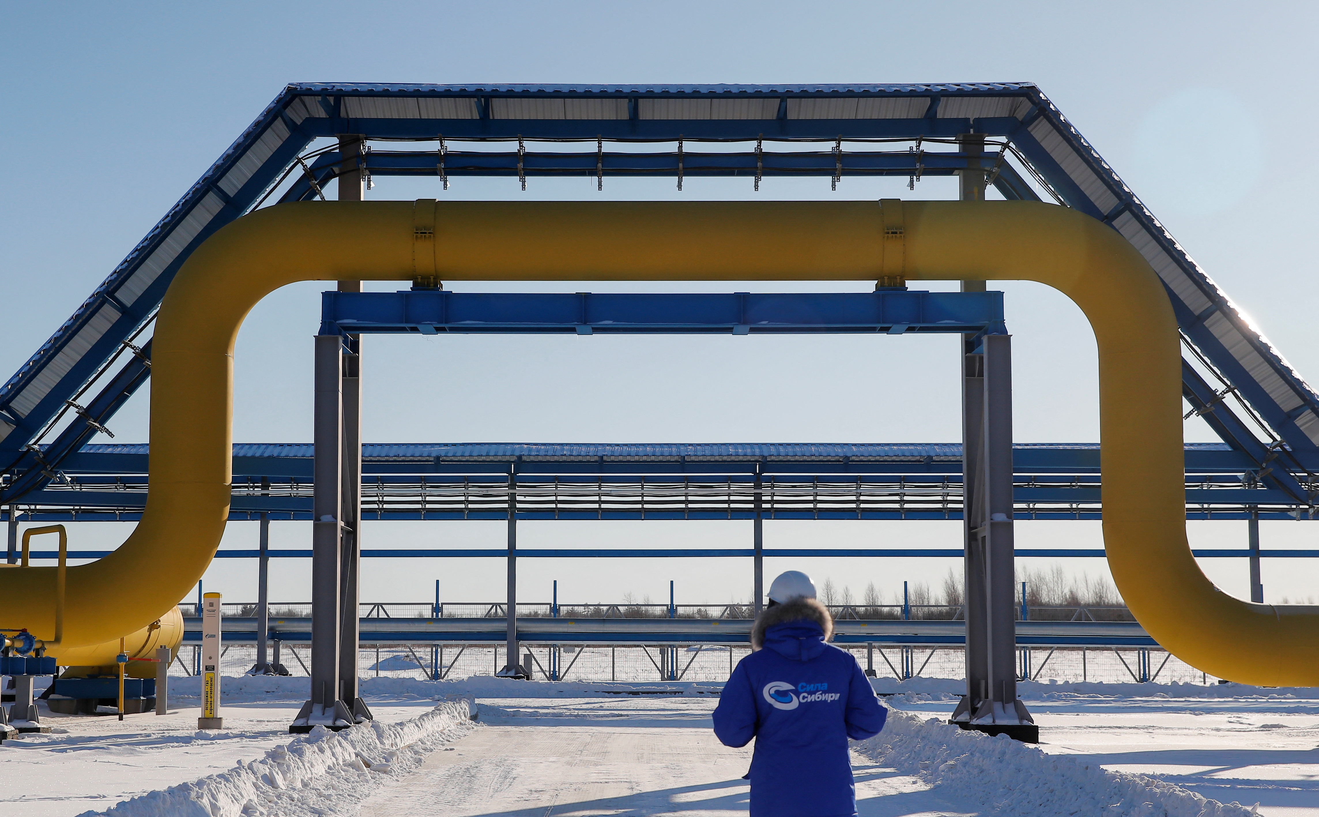 An employee is seen walking past a part of Gazprom's Power Of Siberia gas pipeline in Svobodny, Russia.