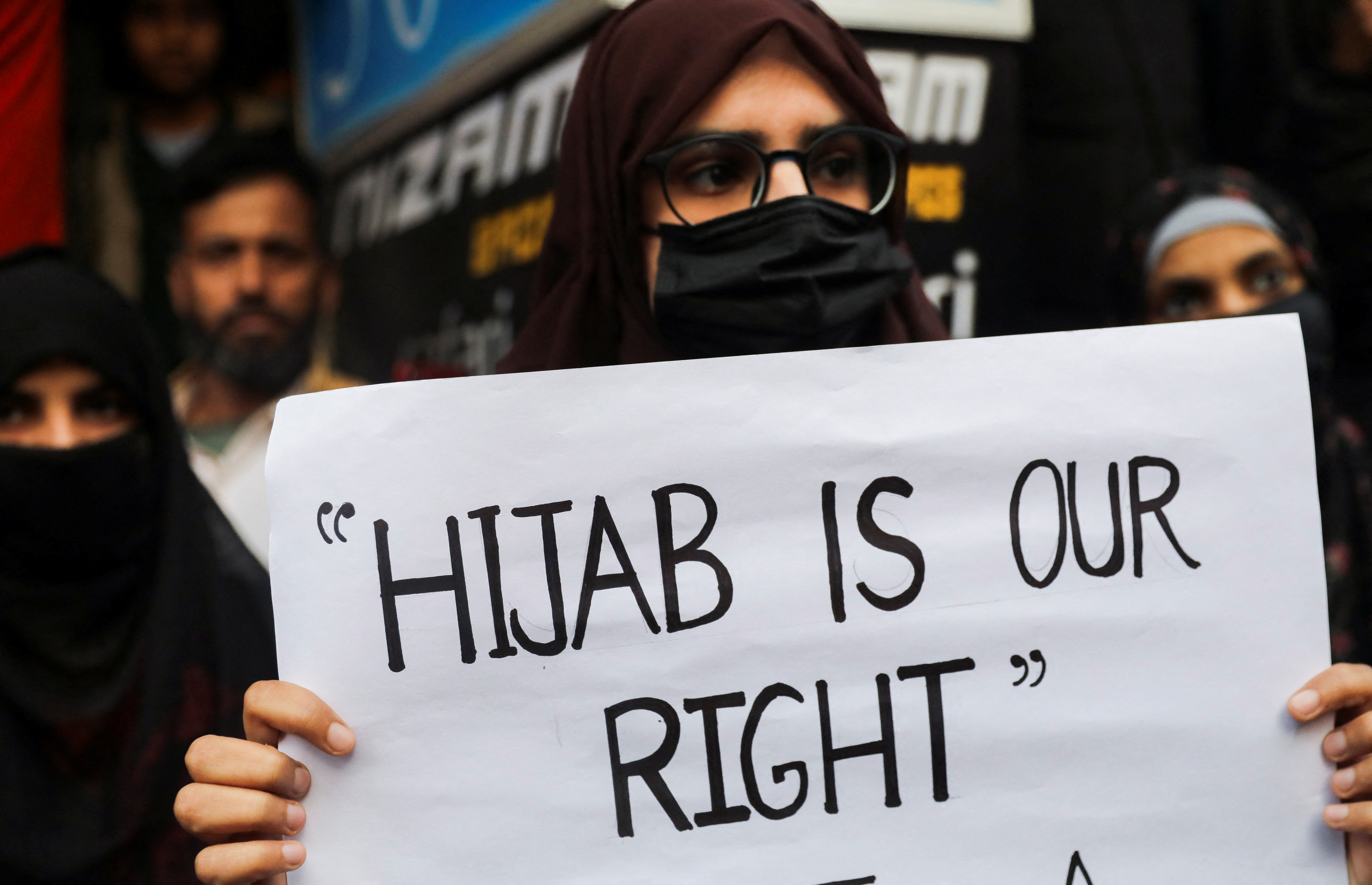 A Muslim woman holds a placard as she takes part in a protest organised by All India Majlis-e-Ittehadul Muslimeen (AIMM) against the recent hijab ban in few colleges of Karnataka state, at Shaheen Bagh in New Delhi, India