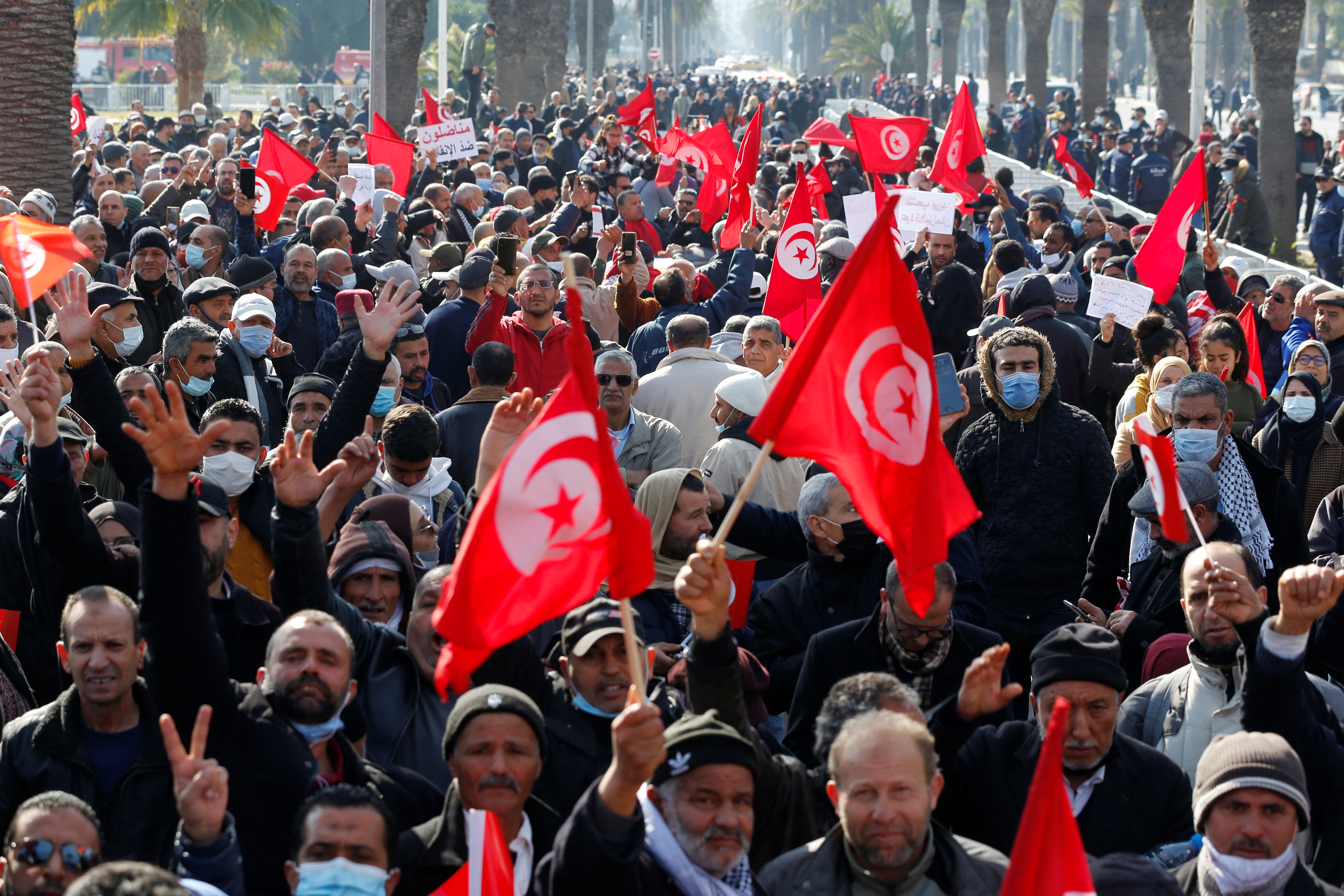 Demonstrators wave the Tunisian flags in the streets of the capital, Tunis.