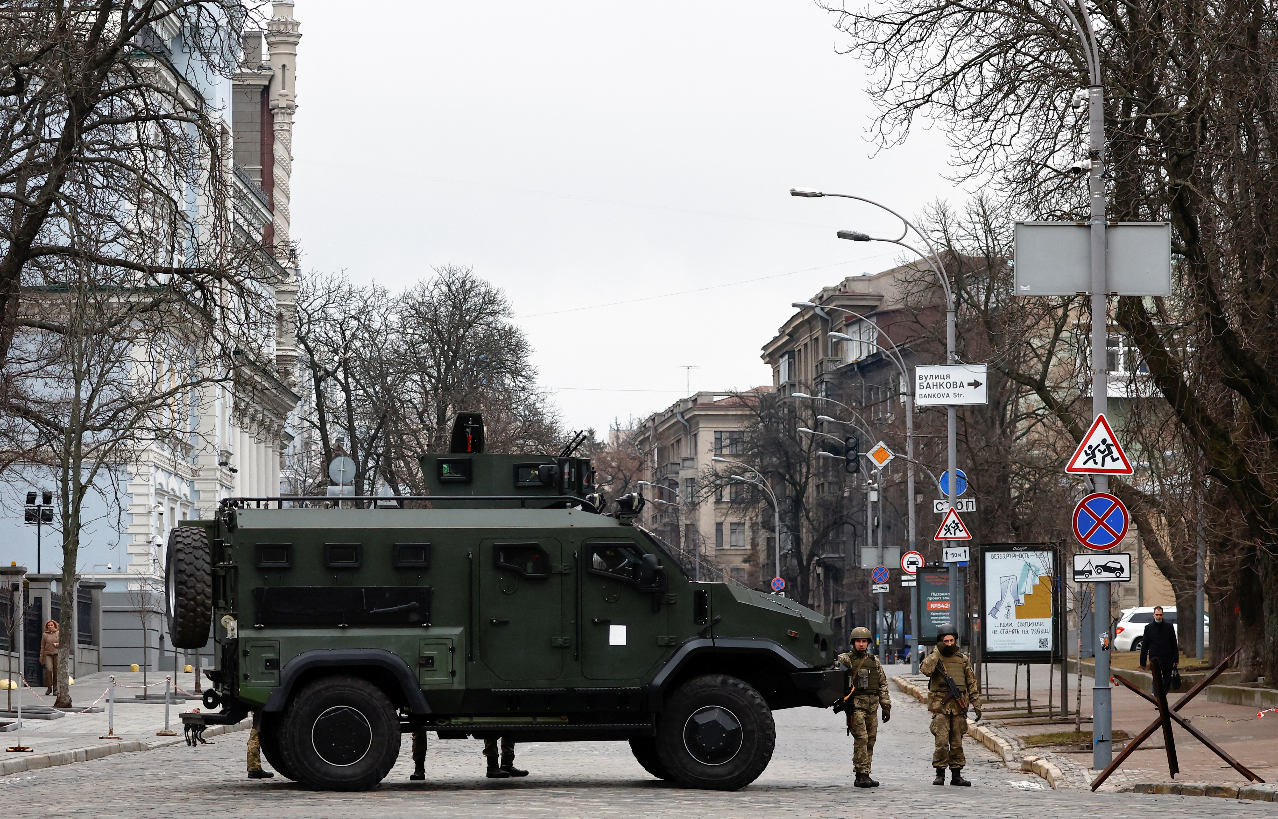Ukrainian military service members guard a road that leads to a government block in Kyiv, Ukraine