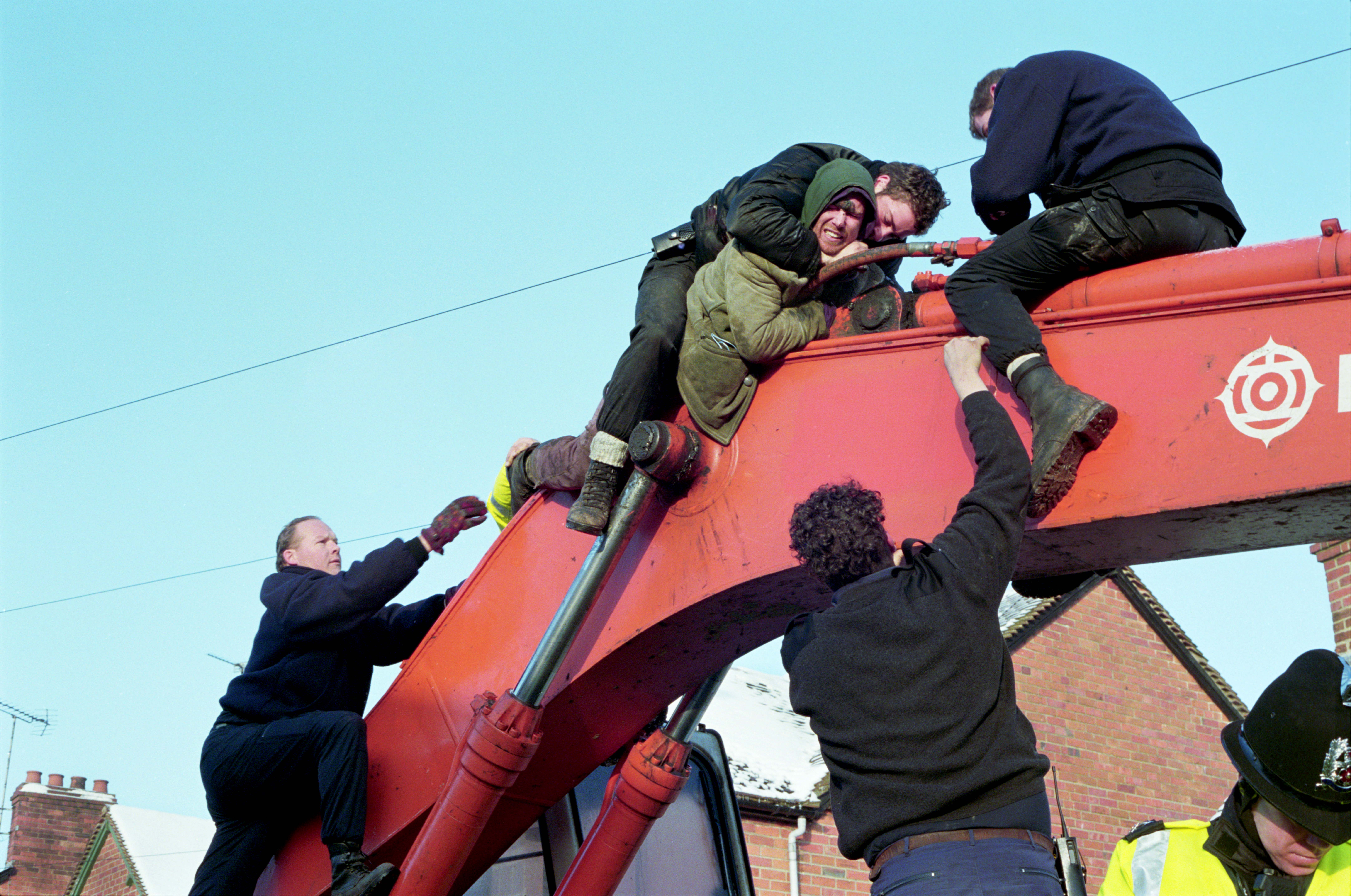 An activist is tackled by police machinery