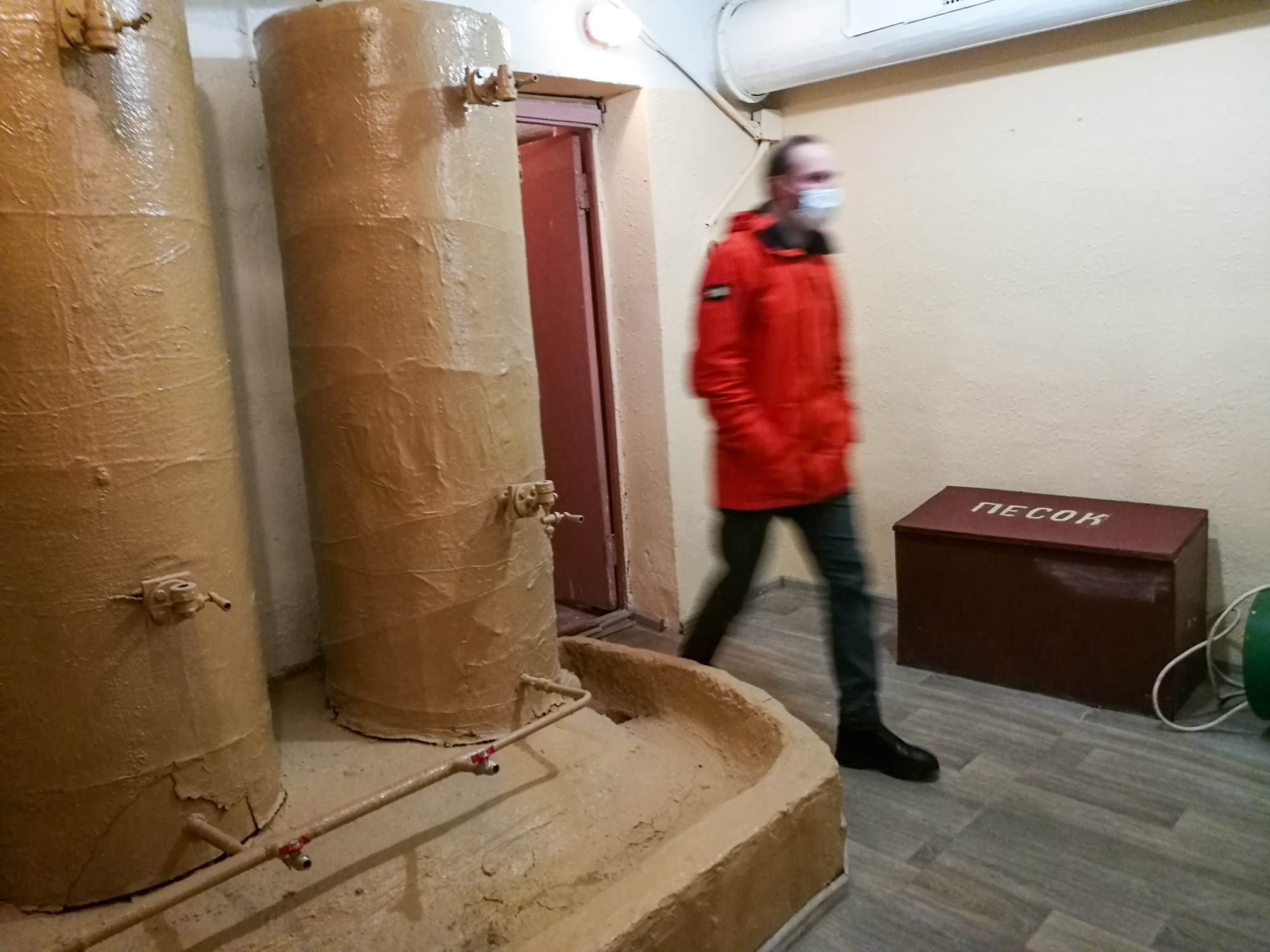 A Ukrainian man near water tanks in a bomb shelter in Kyiv, Ukraine