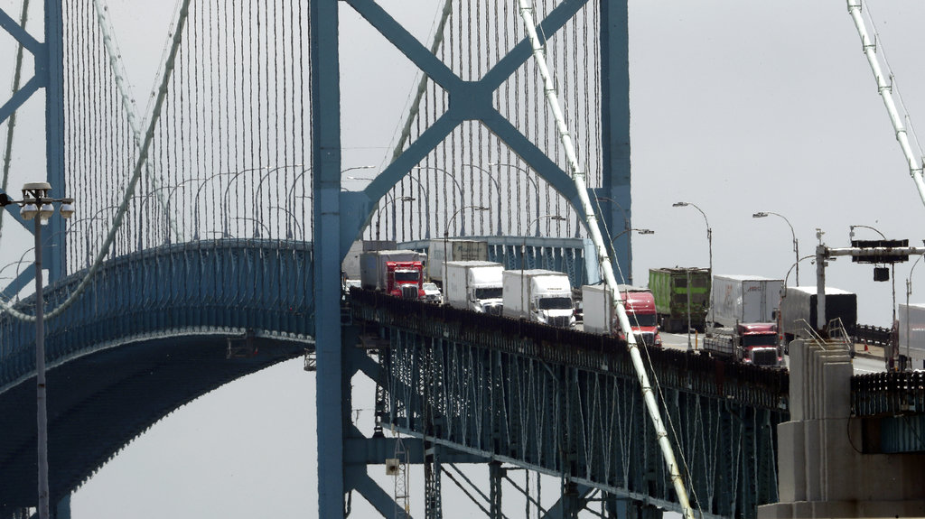trucks cross the Ambassador Bridge from Windsor, Ontario into Detroit. 