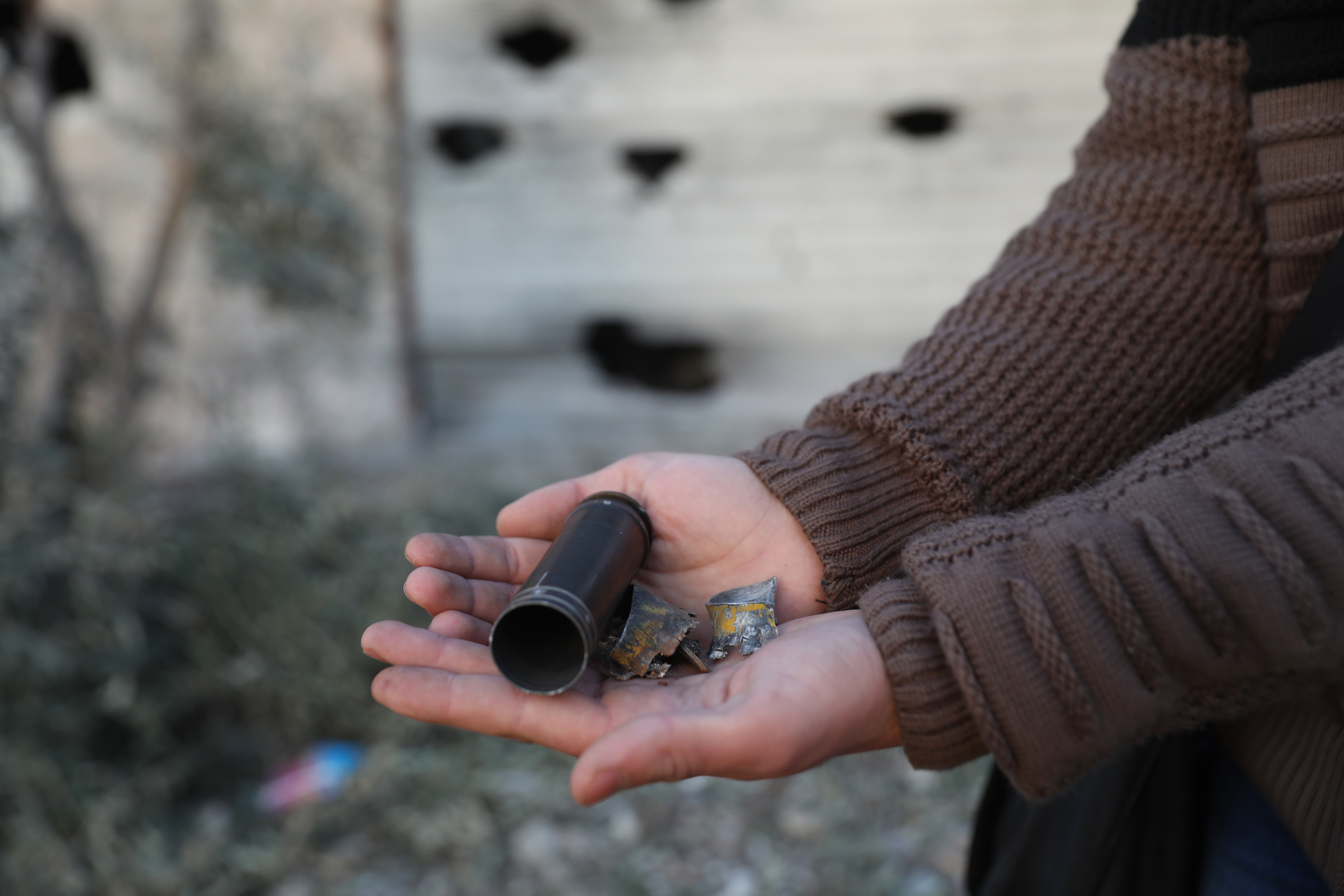 A child shows an empty bullet shell