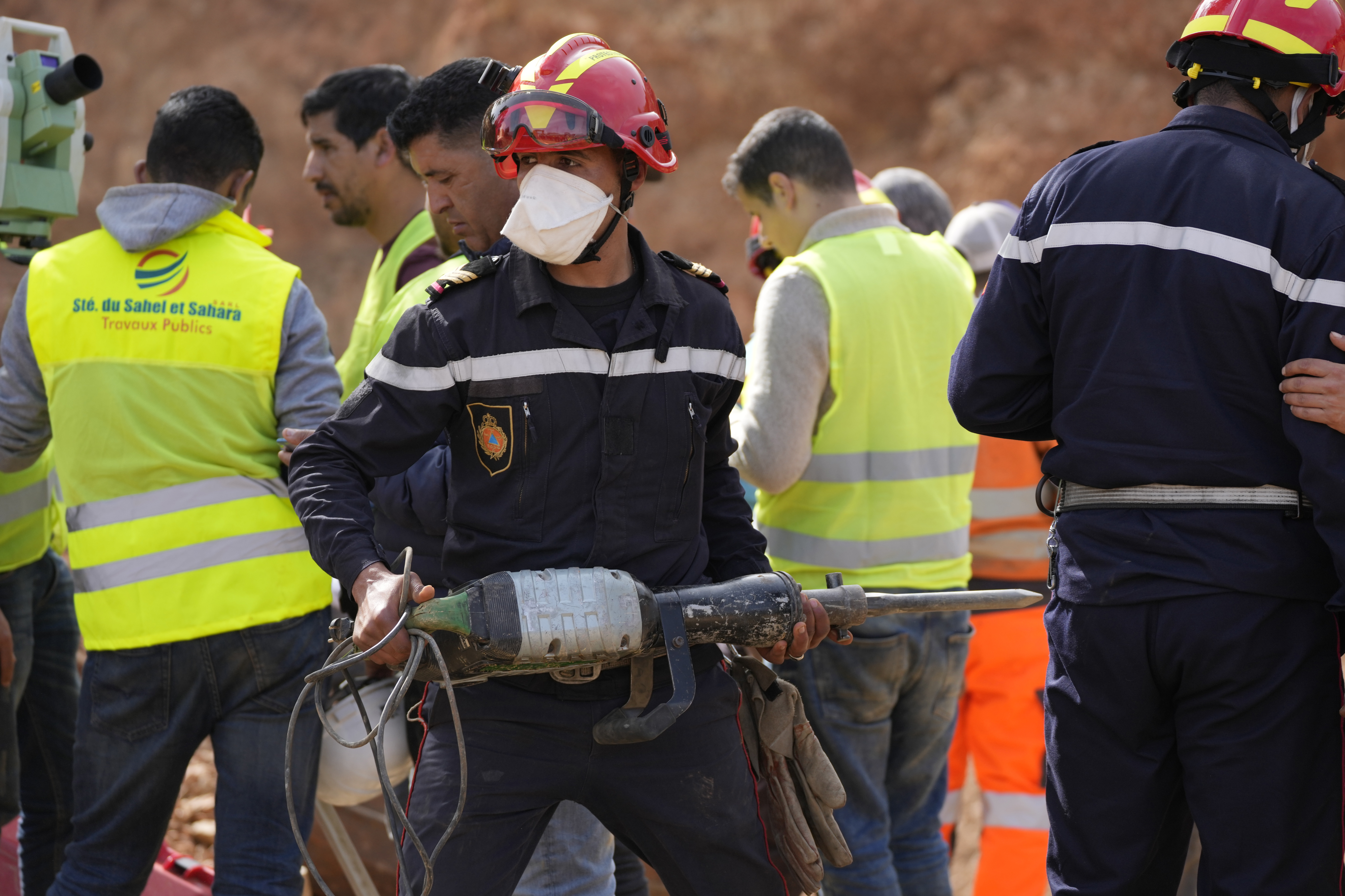 A civil defense worker attempts to rescue a 5 year old boy who fell into a hole