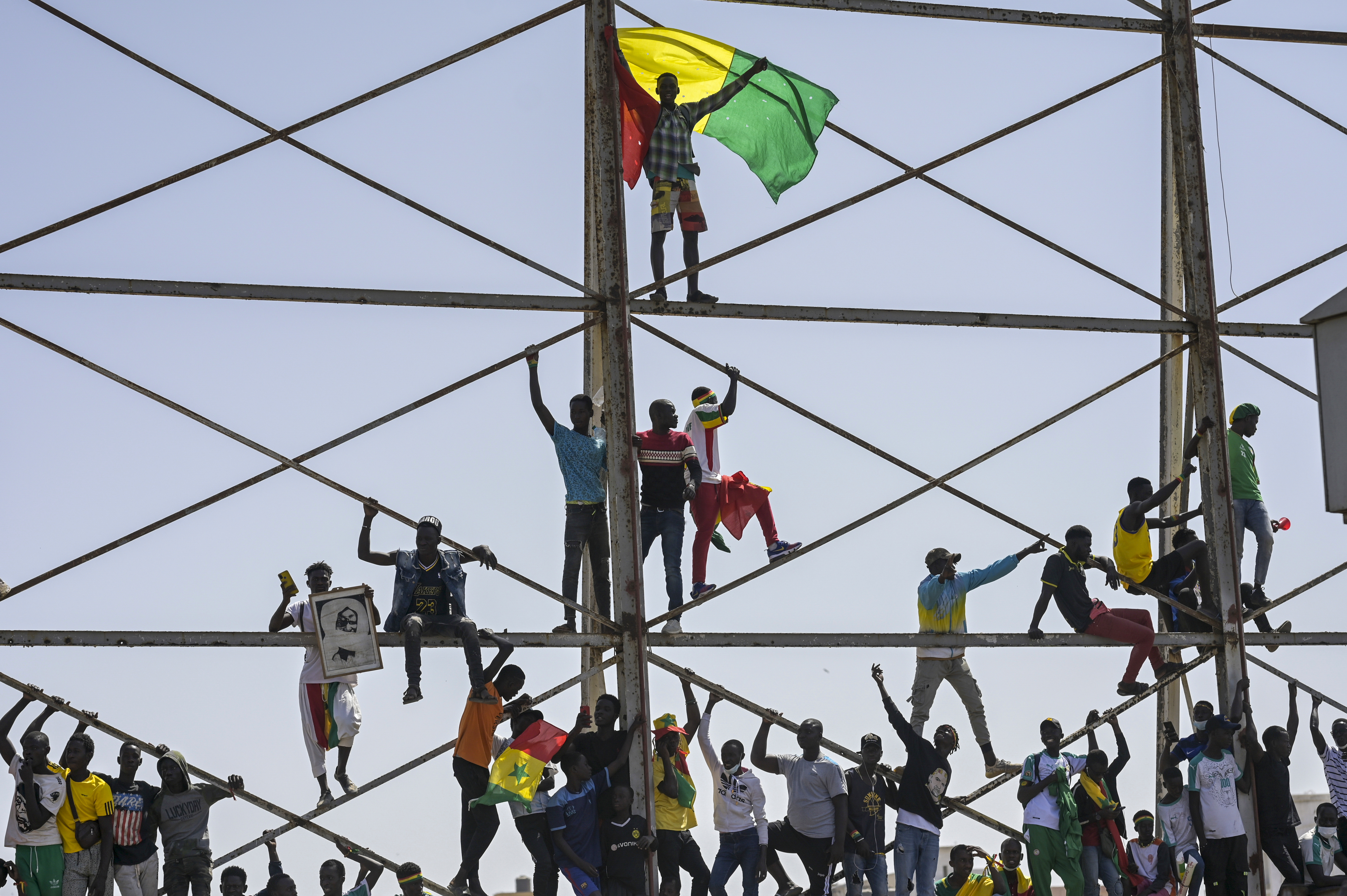 Senegalese soccer fans celebrate as they await the return of their national team