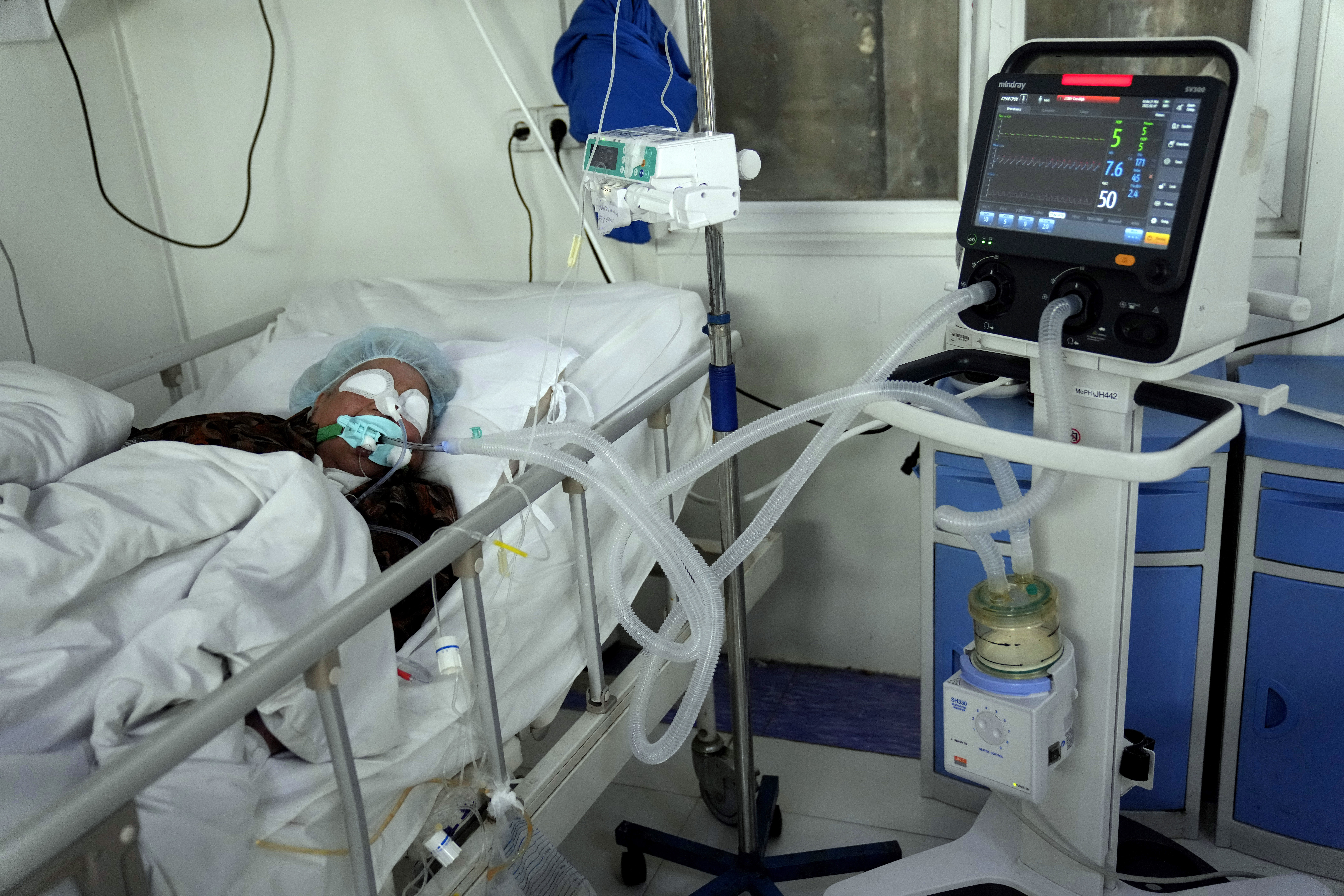 An Afghan patient infected with COVID-19 lies on a bed in the intensive care unit