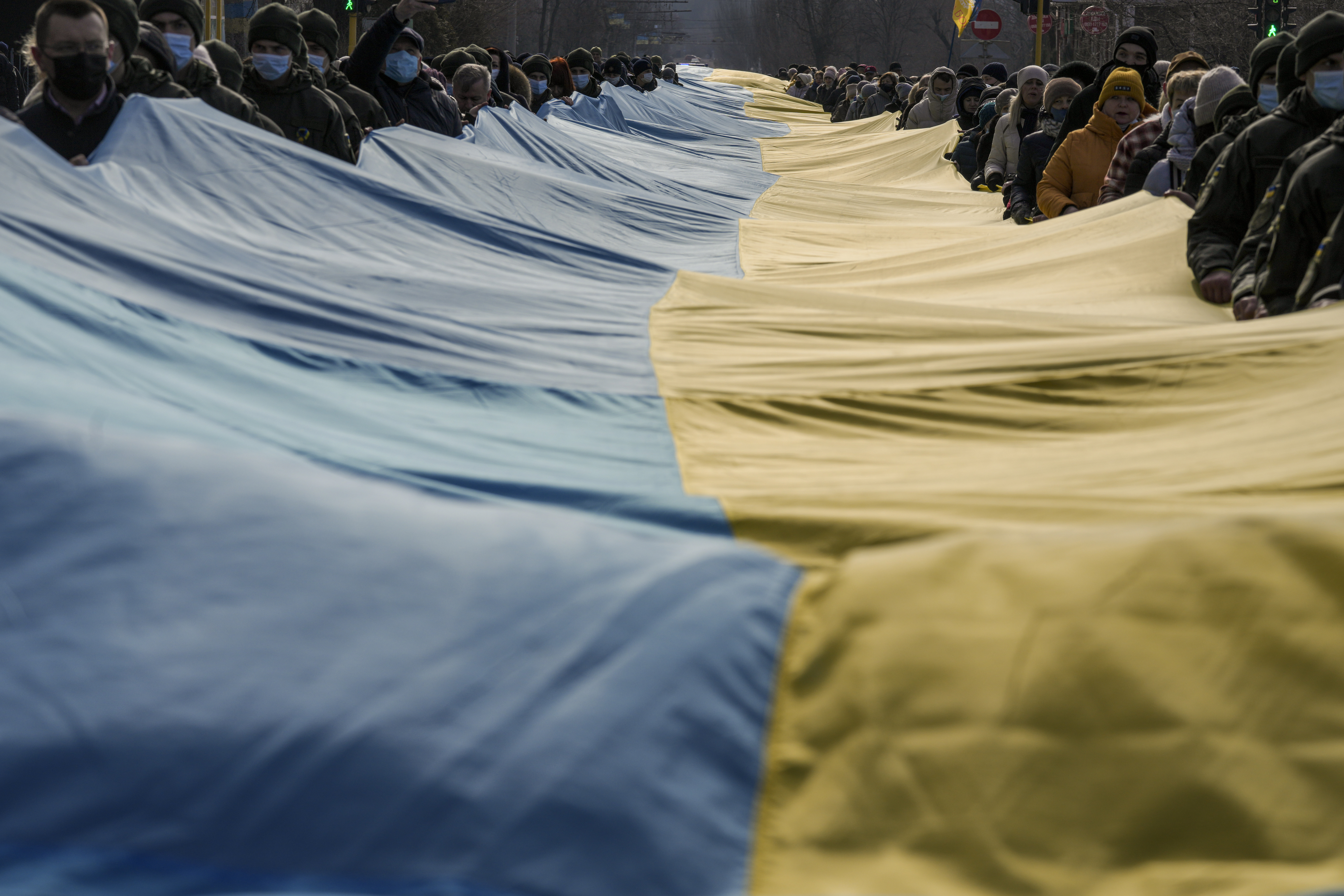 People carry a large Ukrainian flag marking a "day of unity" in Sievierodonetsk, the Luhansk region