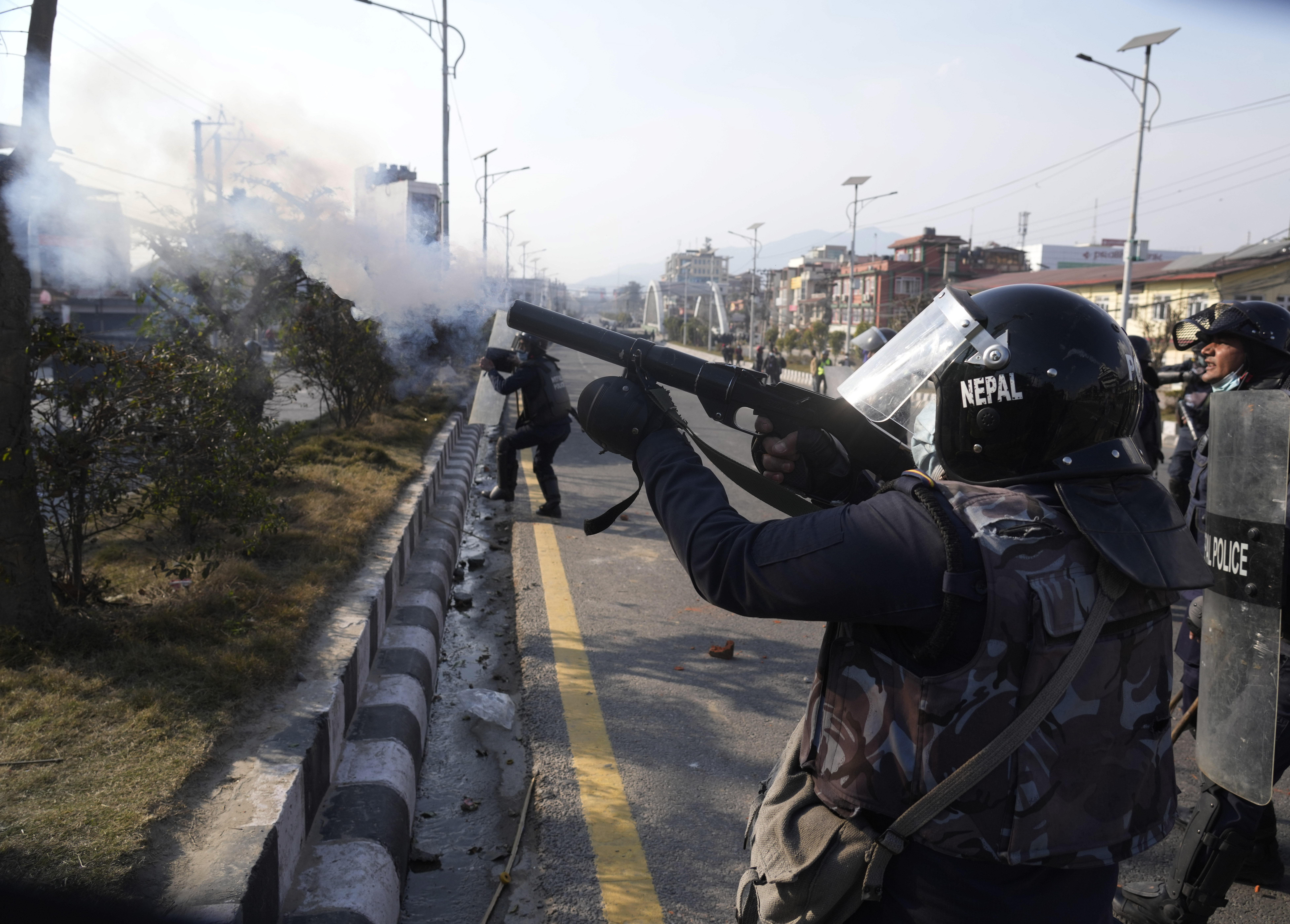 A Nepalese policeman fires tear gas