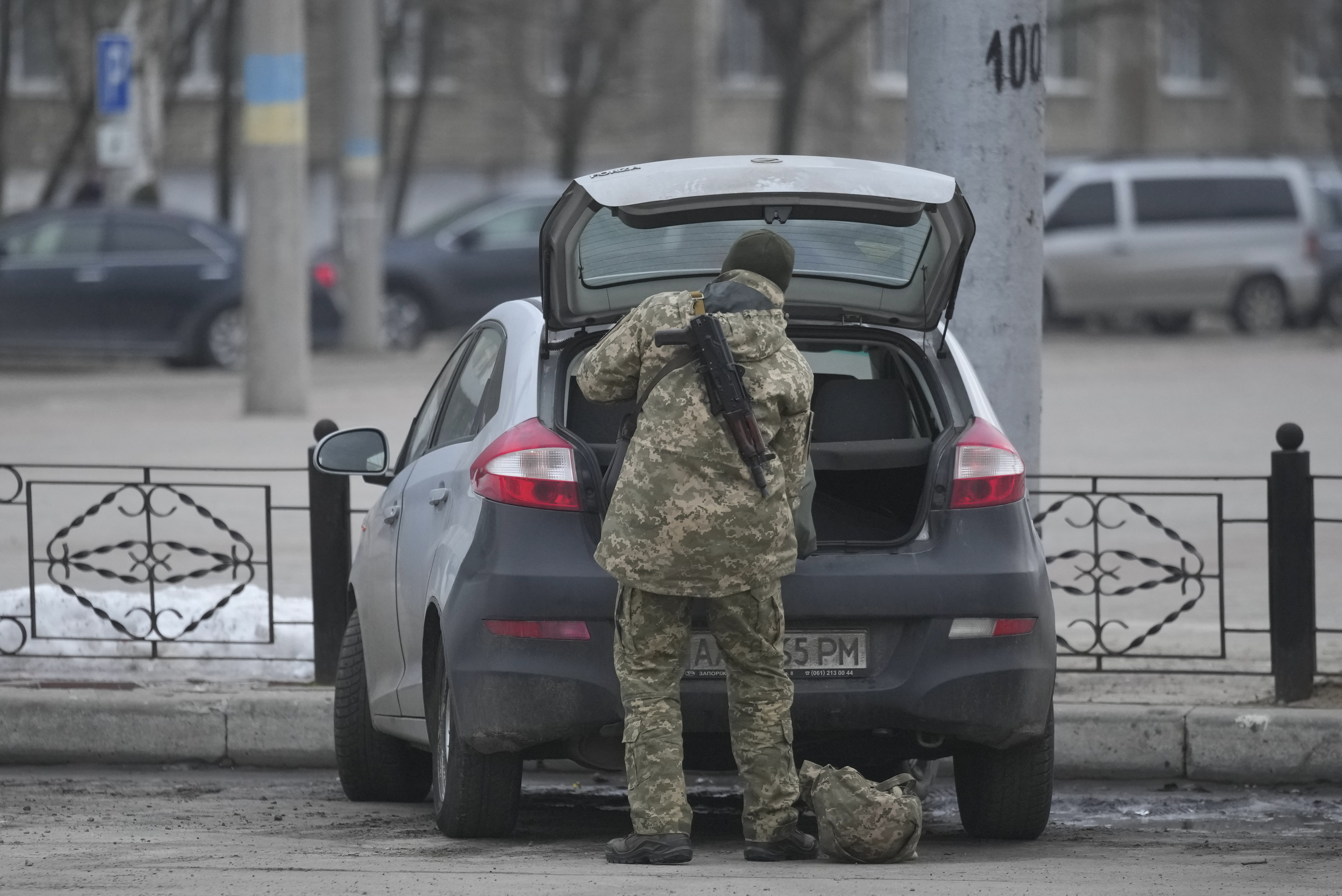 A member of the Ukrainian military takes items from the back of a car in Sievierodonetsk,