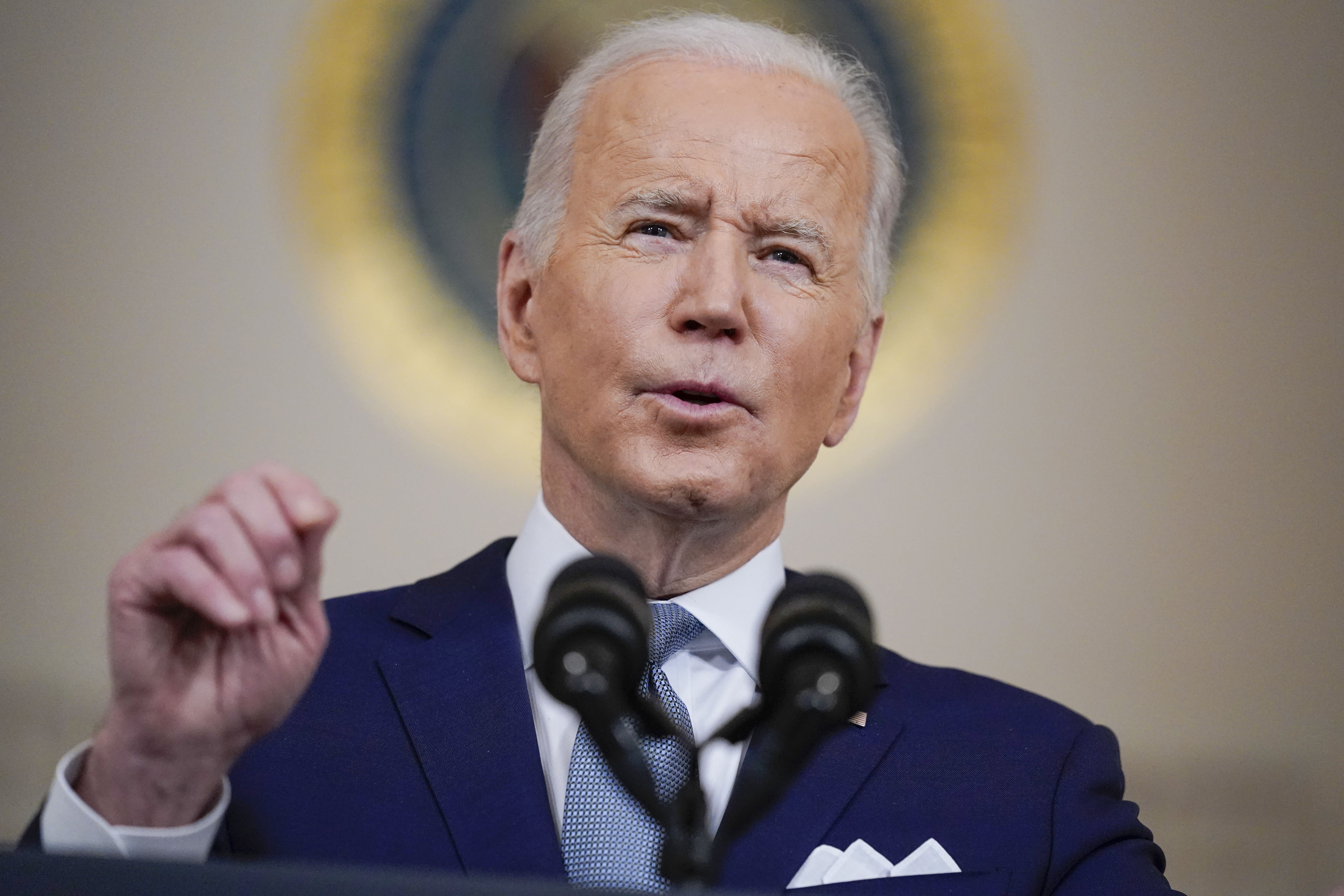 President Joe Biden is seen speaking into a microphone