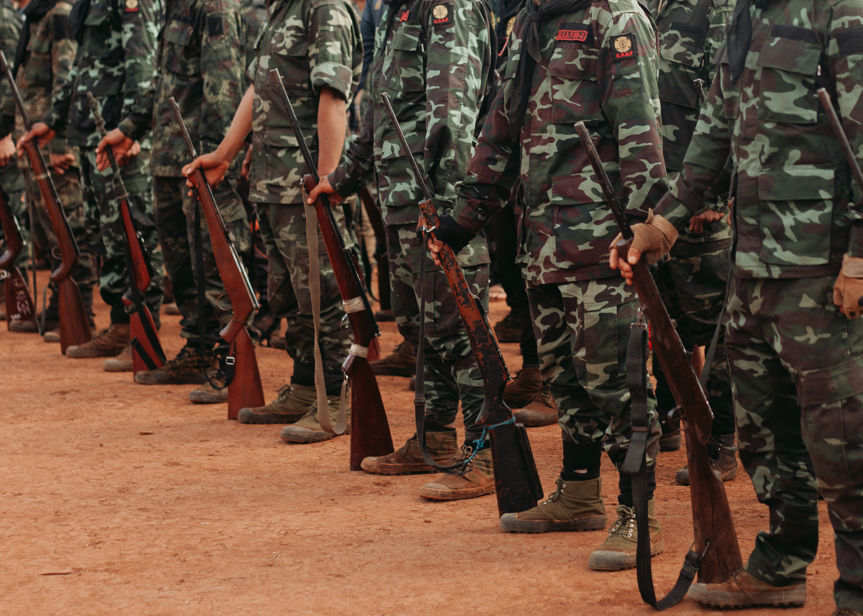 A group of cadets stand at attention at a graduation ceremony.