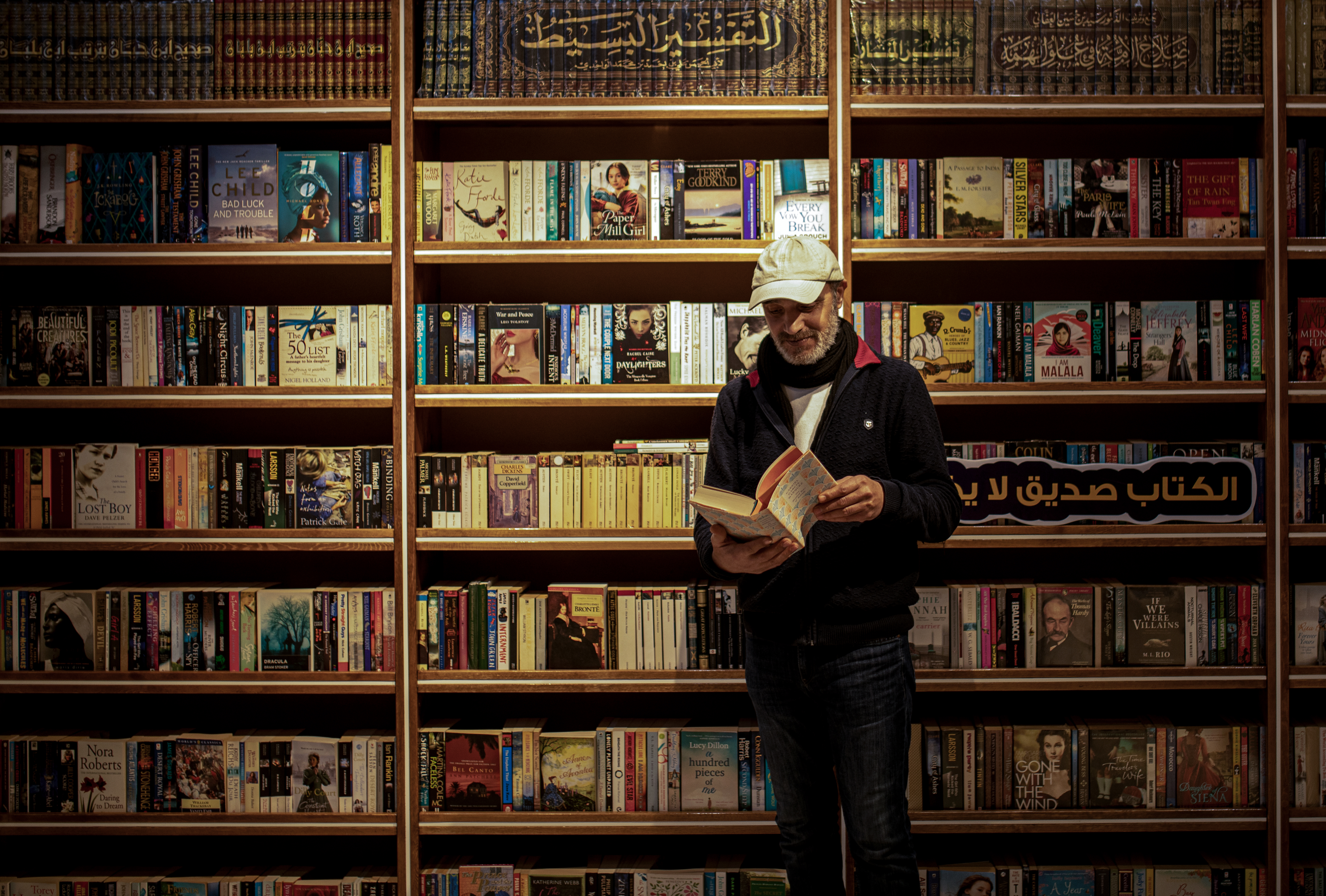 A man reads a book in front of a bookstore