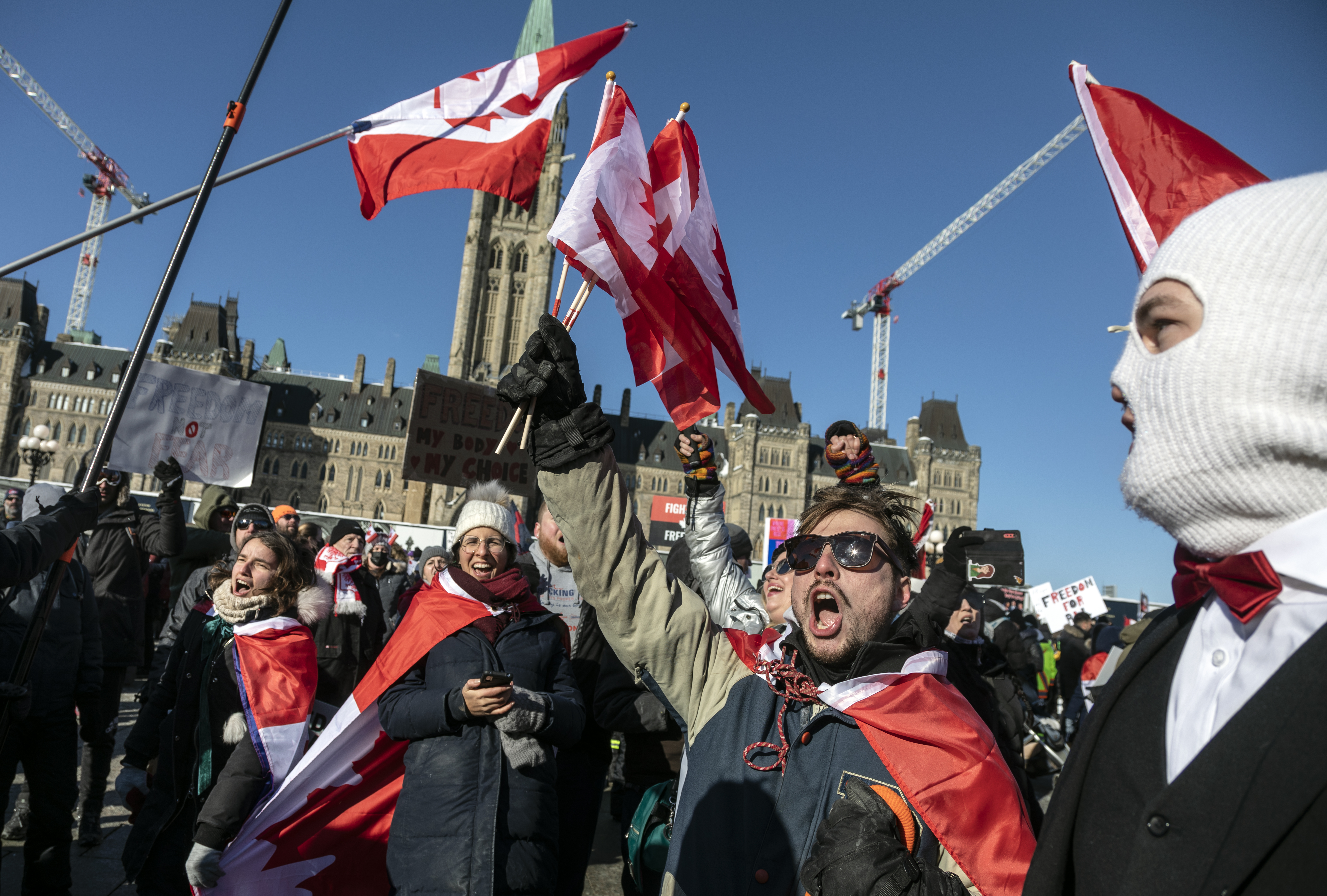 Protesters sing “O Canada” in front of the Partliament building.