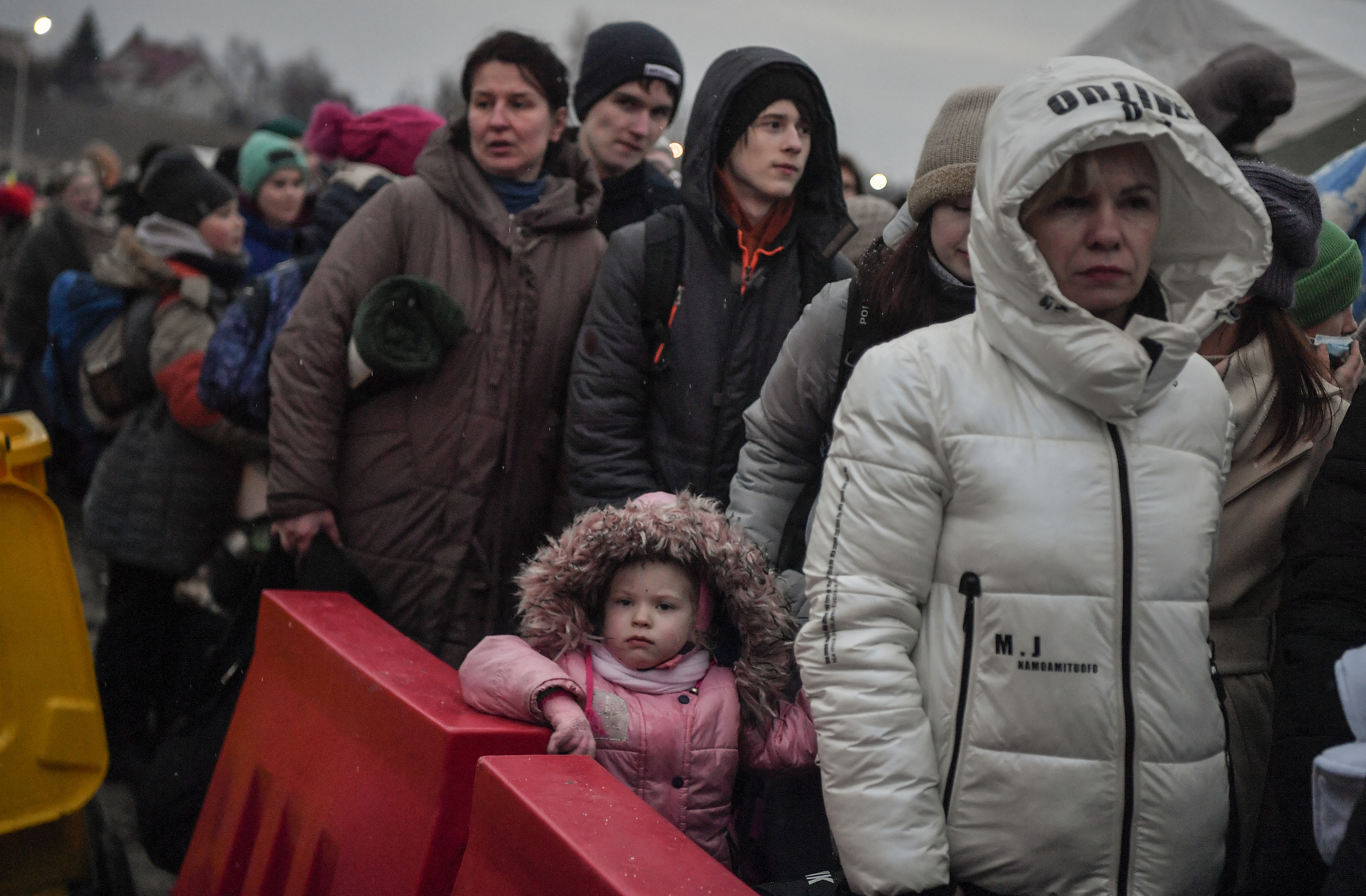 Ukrainian refugees wait for their transportation after crossing the border into Poland at the border crossing in Medyka, southeastern Poland.