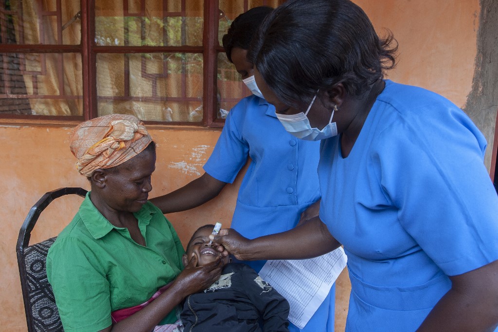 Health Surveillance Assistant (HAS) Matilda Mulupwa (R) gives a dose of the polio vaccine to a baby, on the first day of the Polio vaccine campaign in Lilongwe.