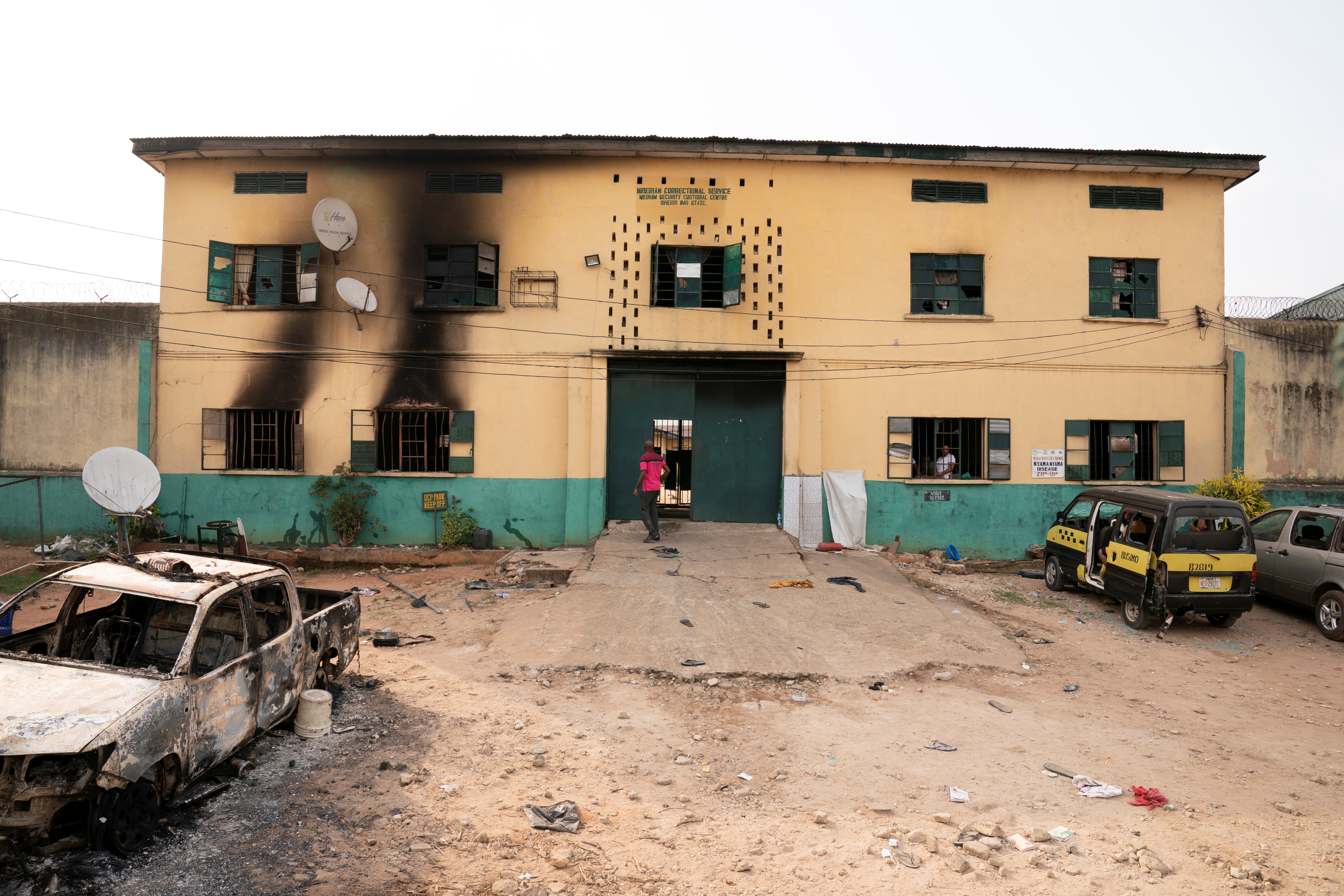 A man is seen standing in front of the main gate of the Nigerian Correctional Services facility that was attacked by gunmen.