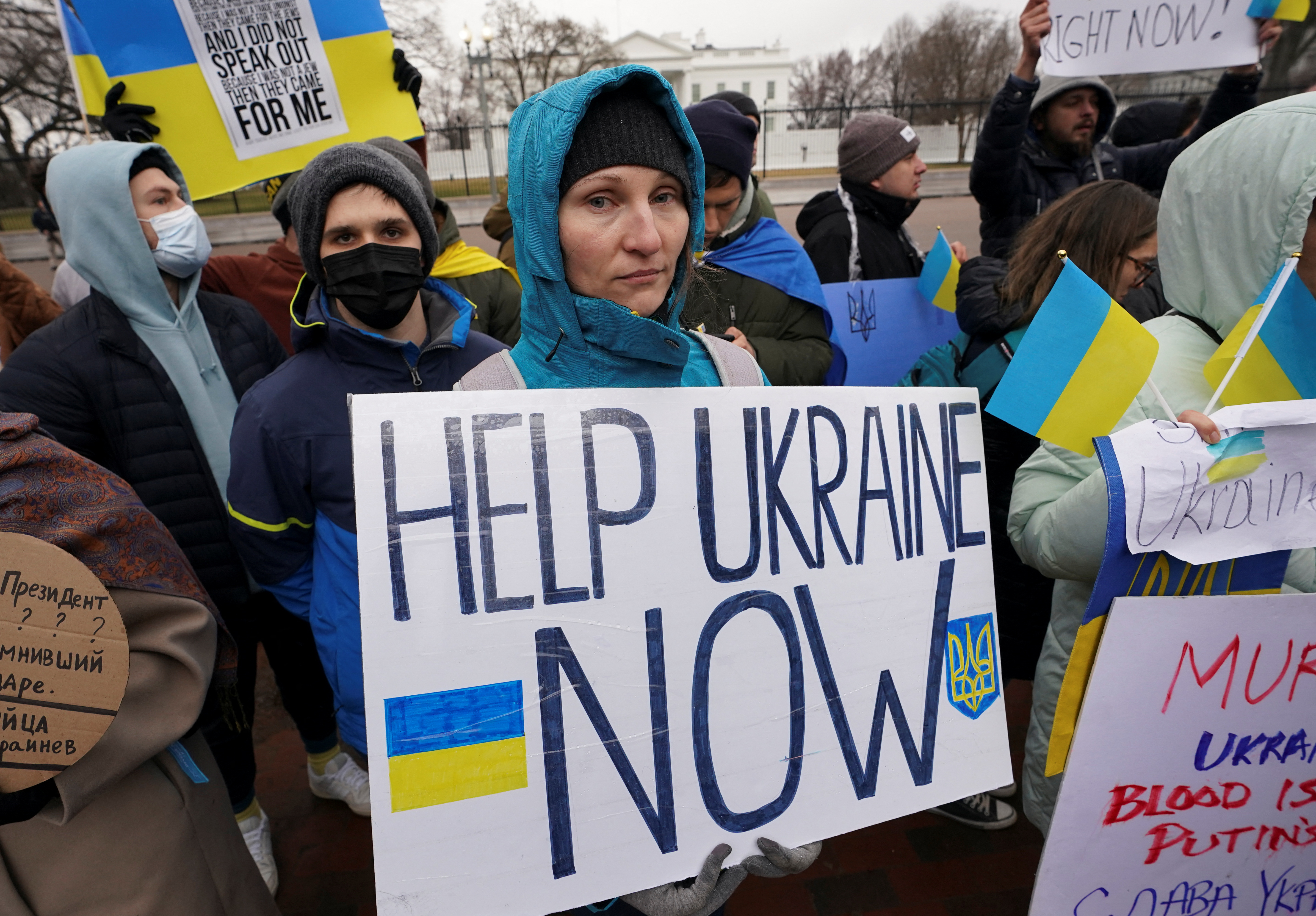 A woman holds a sign that reads 'Help Ukraine now' at a rally outside the White House