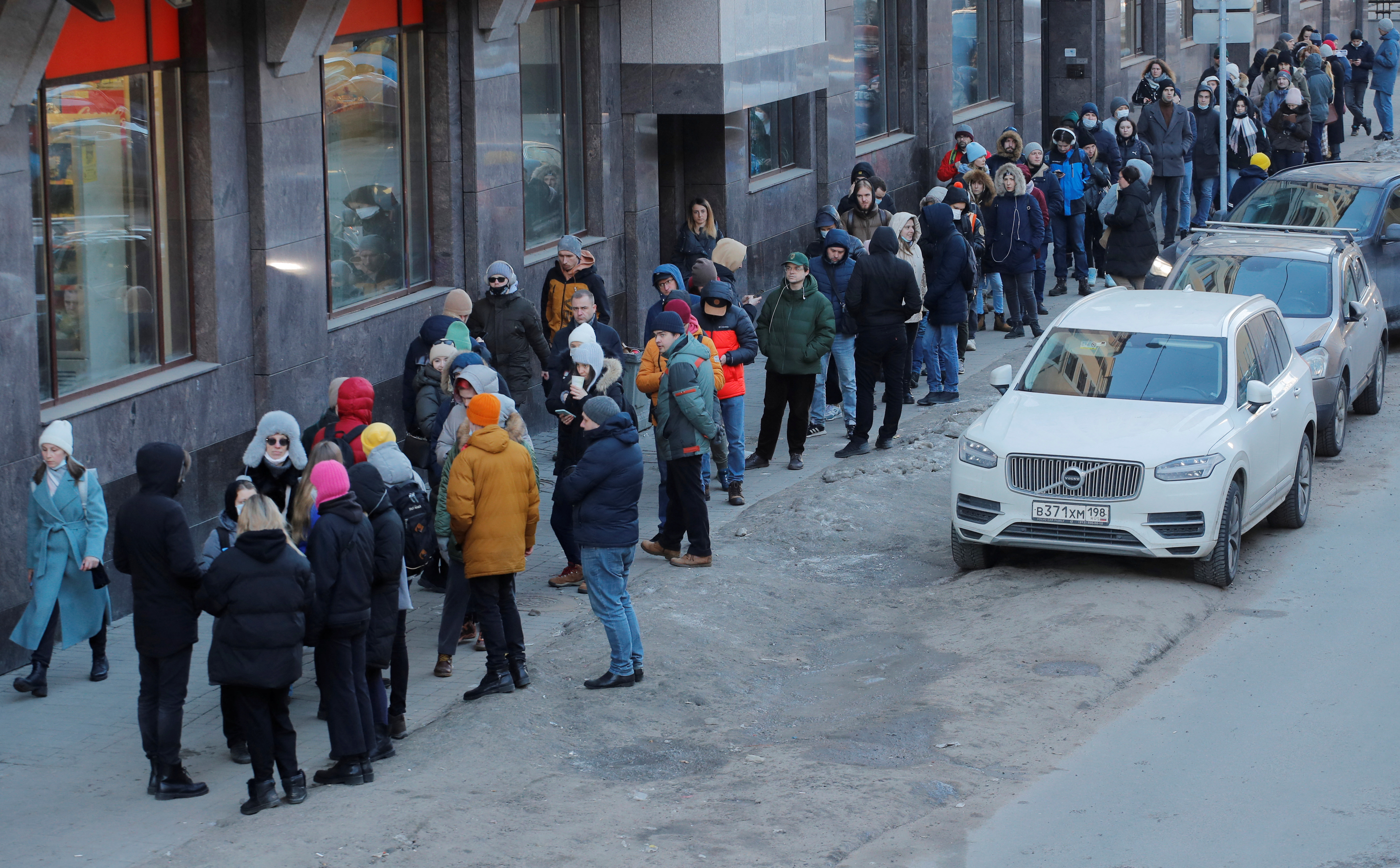 People stand in line to use an ATM money machine in Saint Petersburg, Russia.