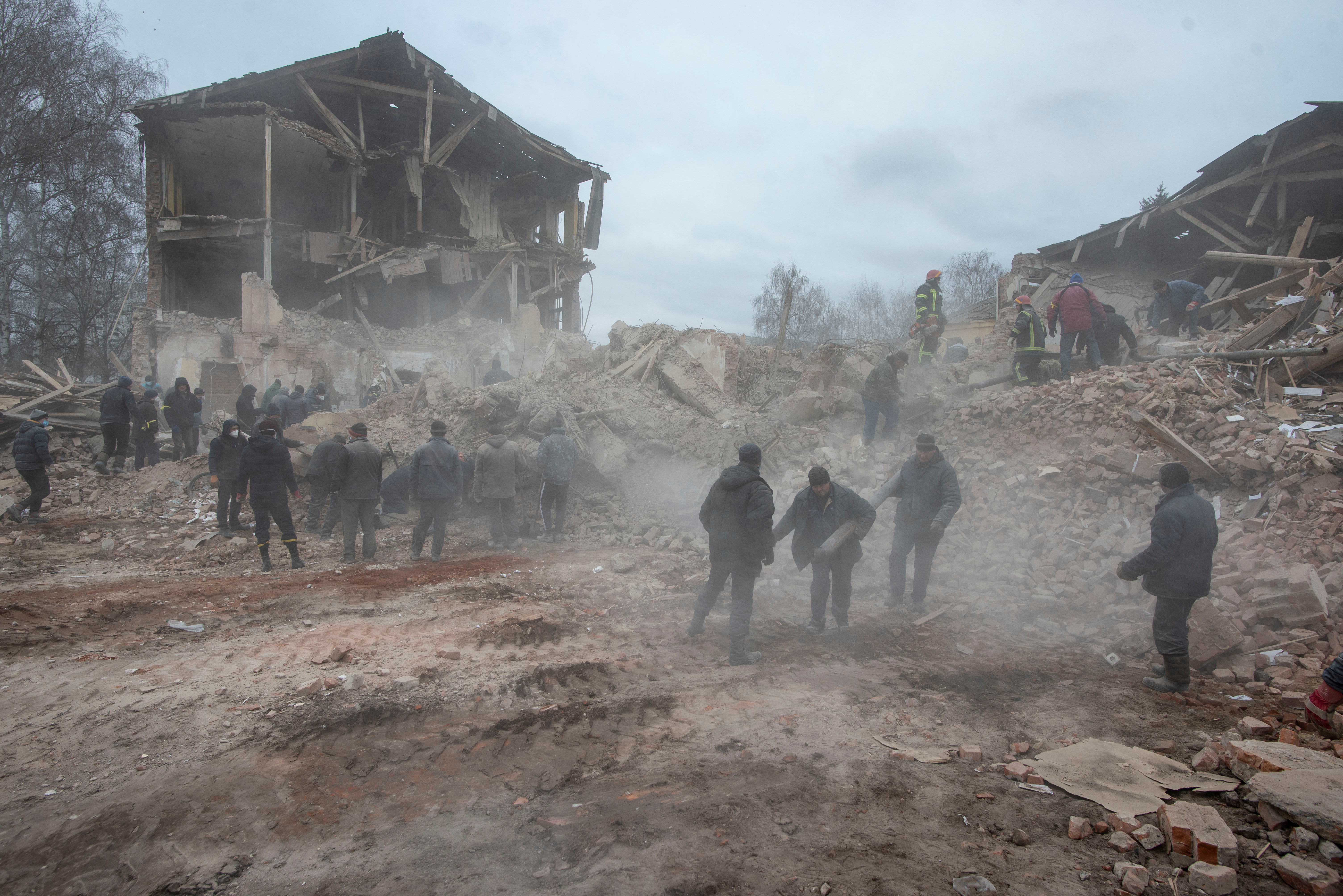 People are seen removing debris in Okhtyrka