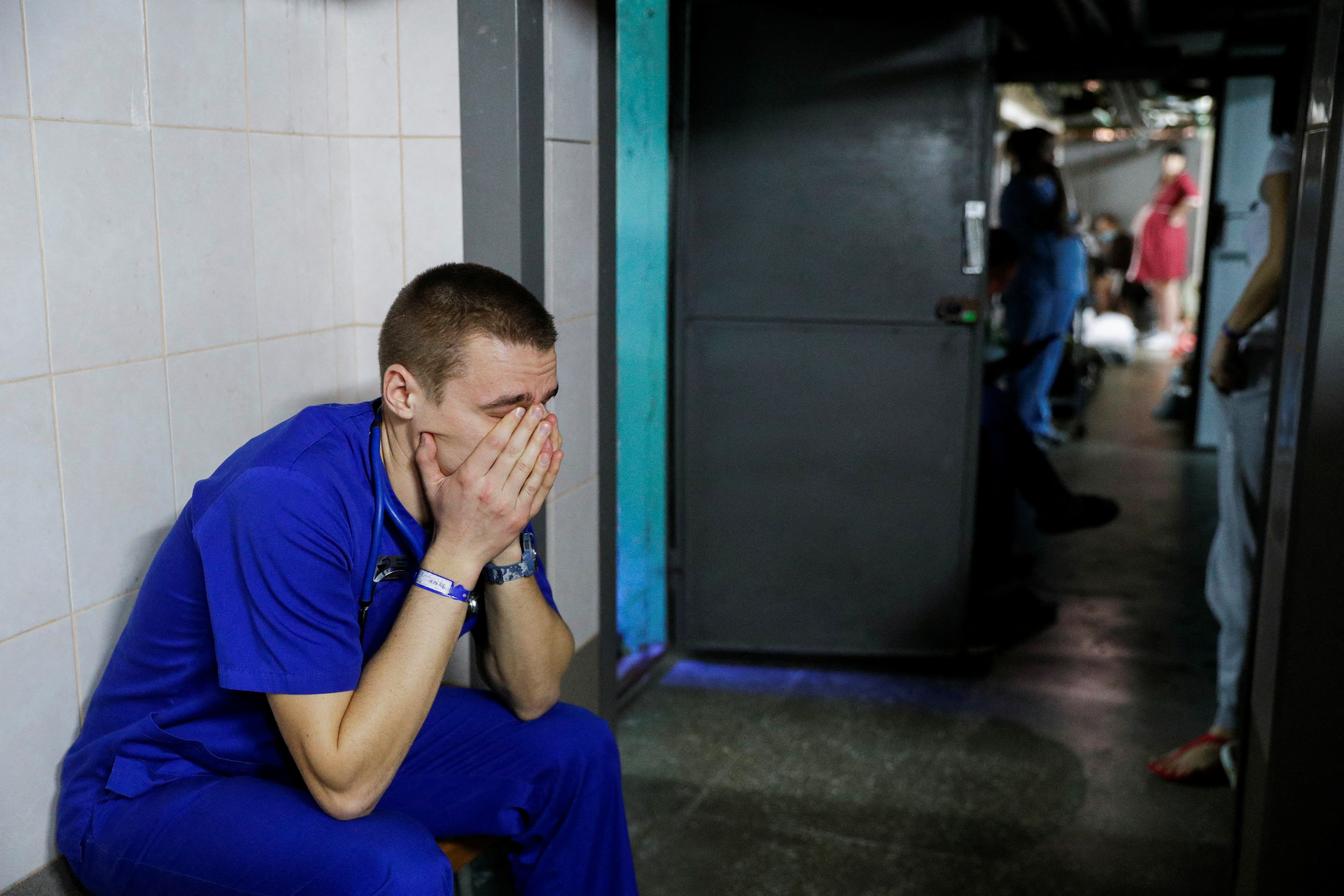 A doctor holds his face in his hands in the basement of a perinatal centre in Kyiv