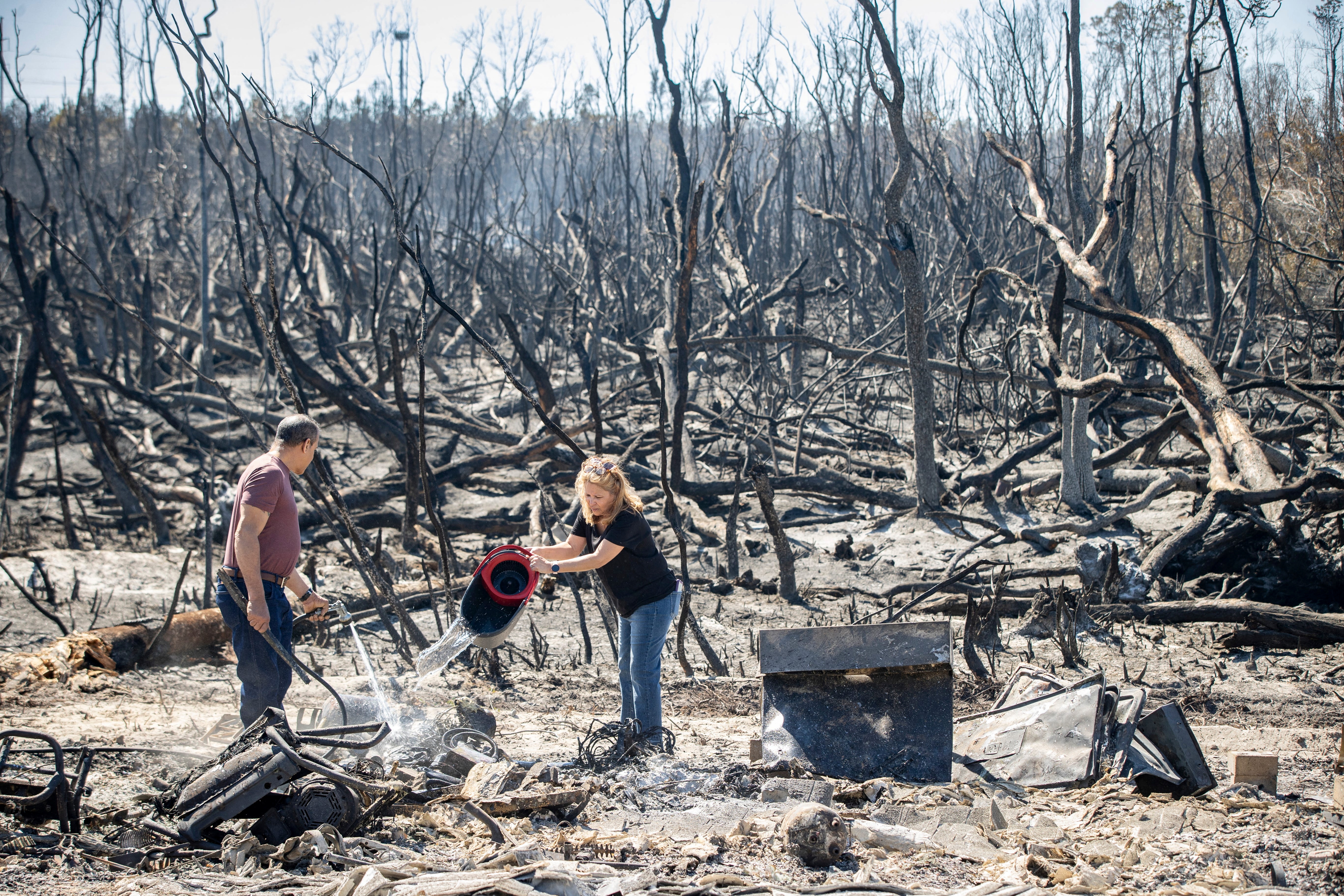 People pouring water on blaze