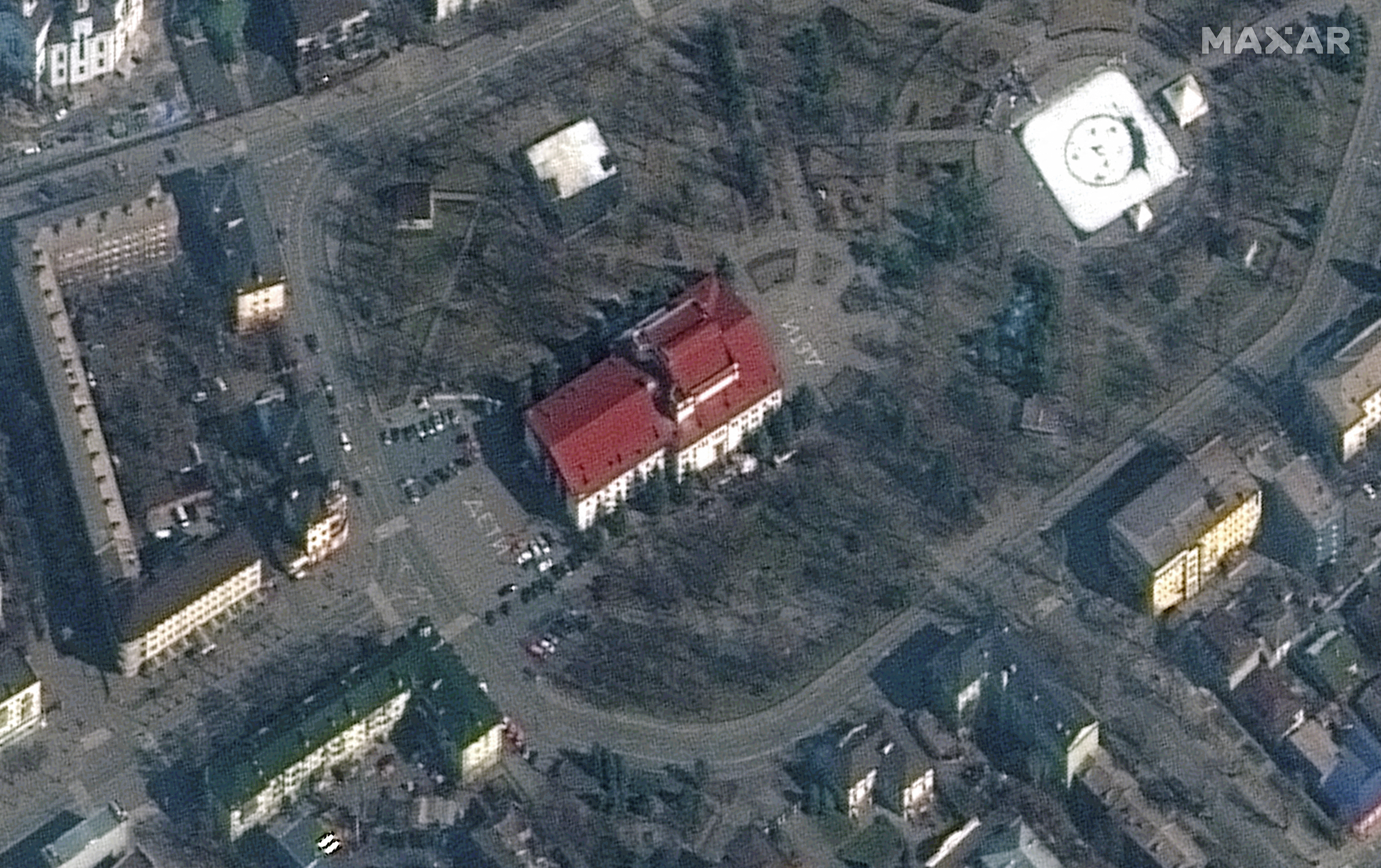 A satellite image shows a closer view of Mariupol Drama Theatre before bombing, as a word "children" in Russian is written in large white letters on the pavement in front of and behind the building, in Mariupol, Ukraine, March 14, 2022.