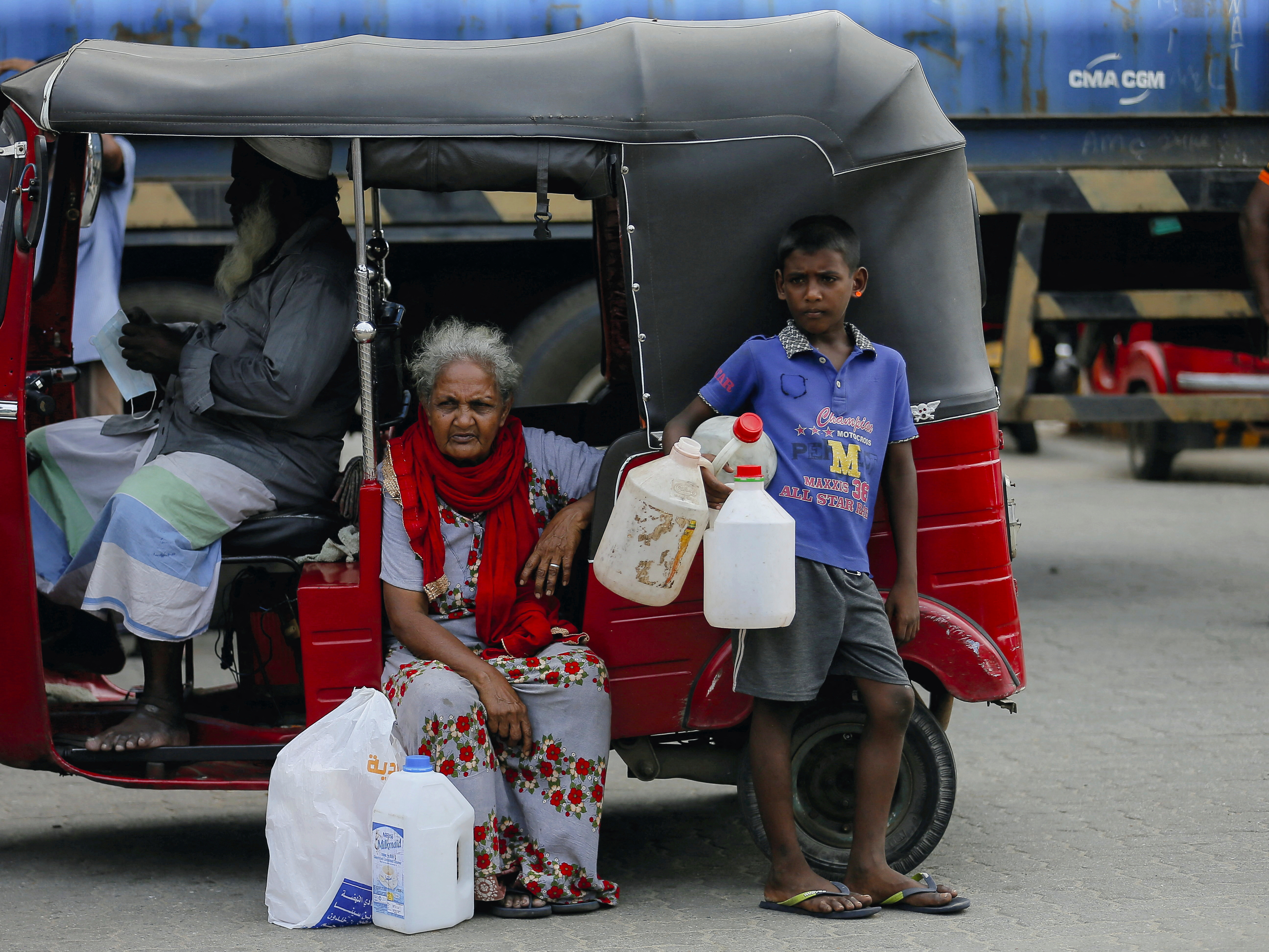 A boy holds empty containers in Sri Lanka