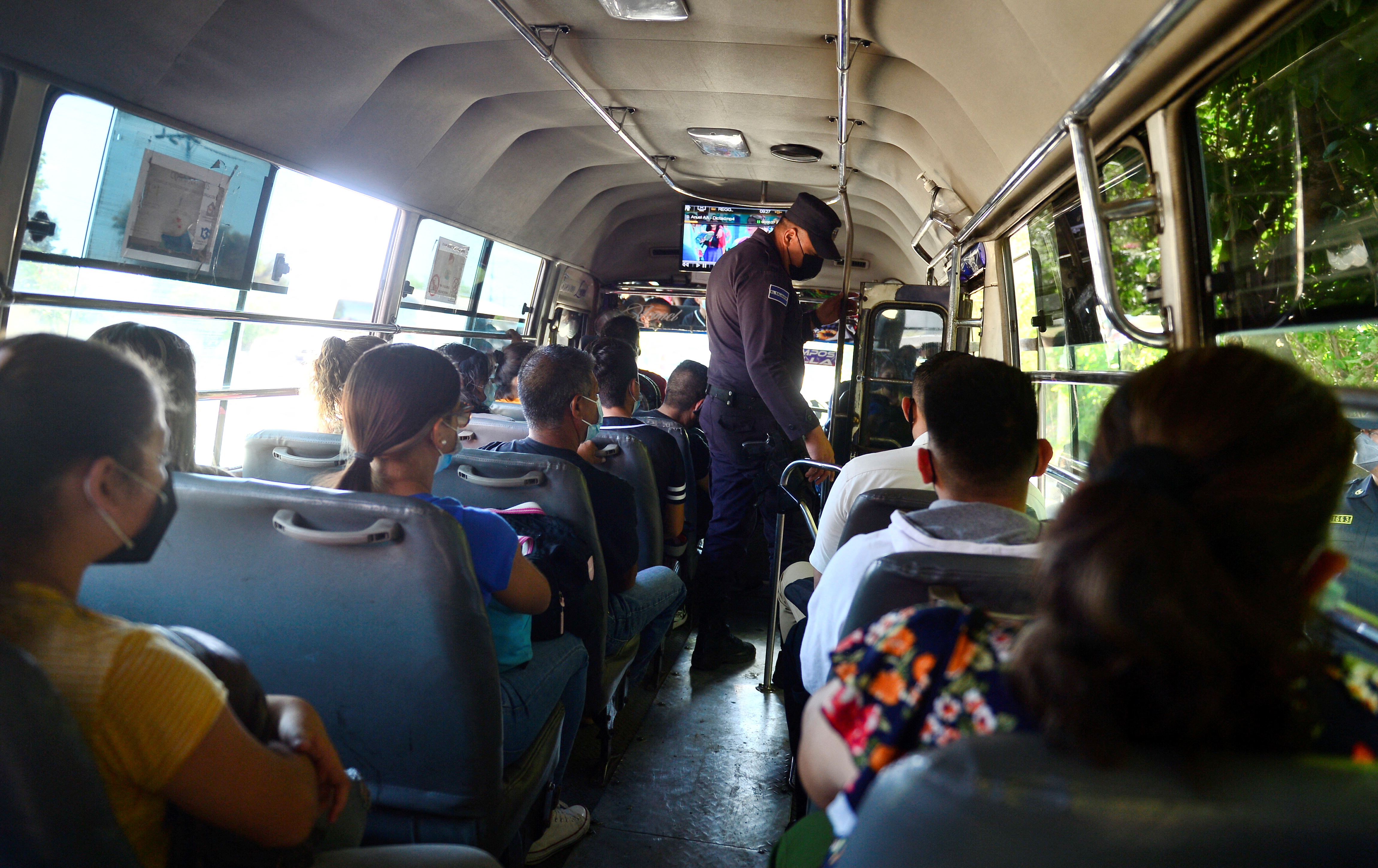 a police officer checks documents on a bus
