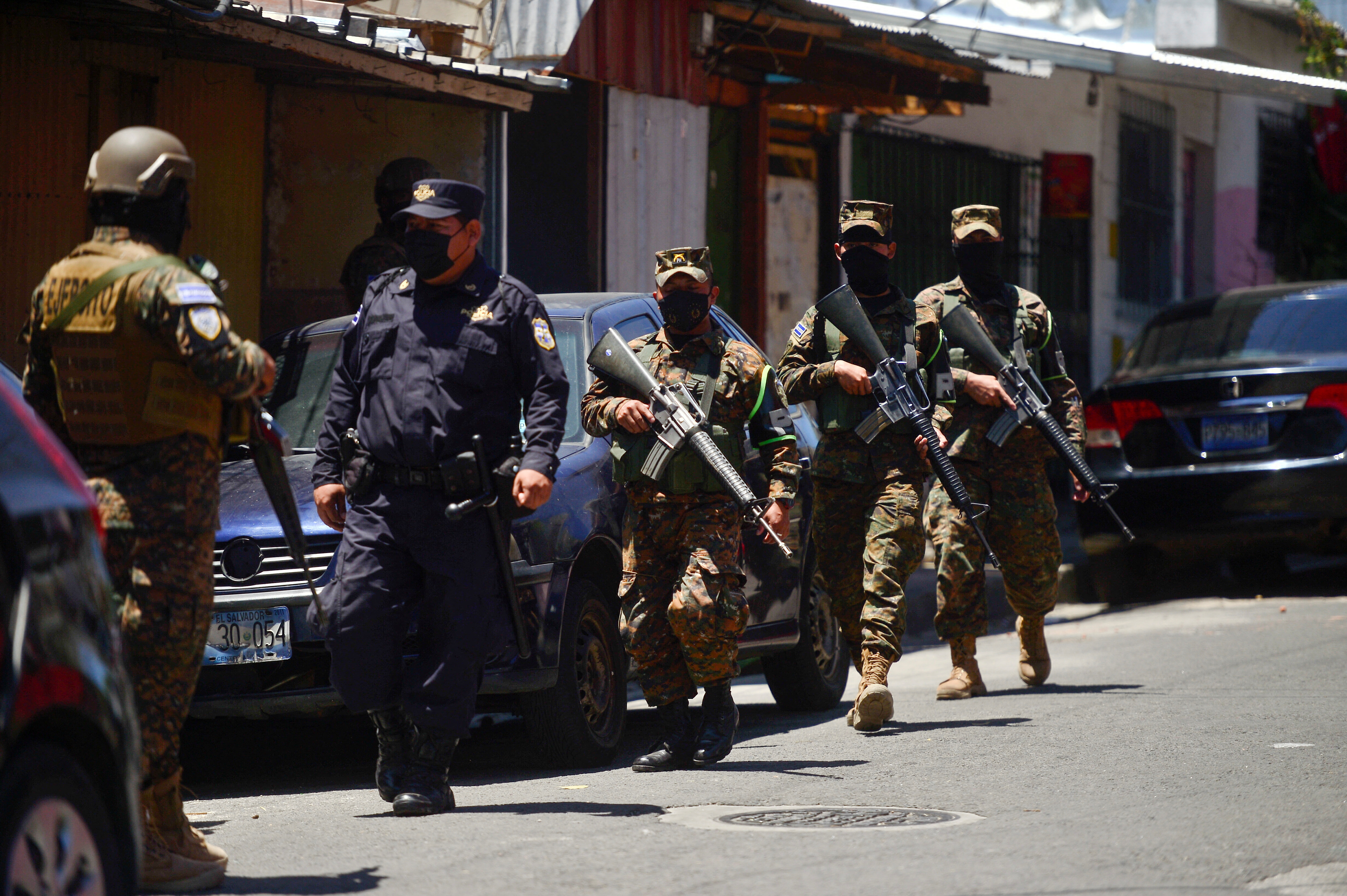 police officer walks near soldiers during a patrol