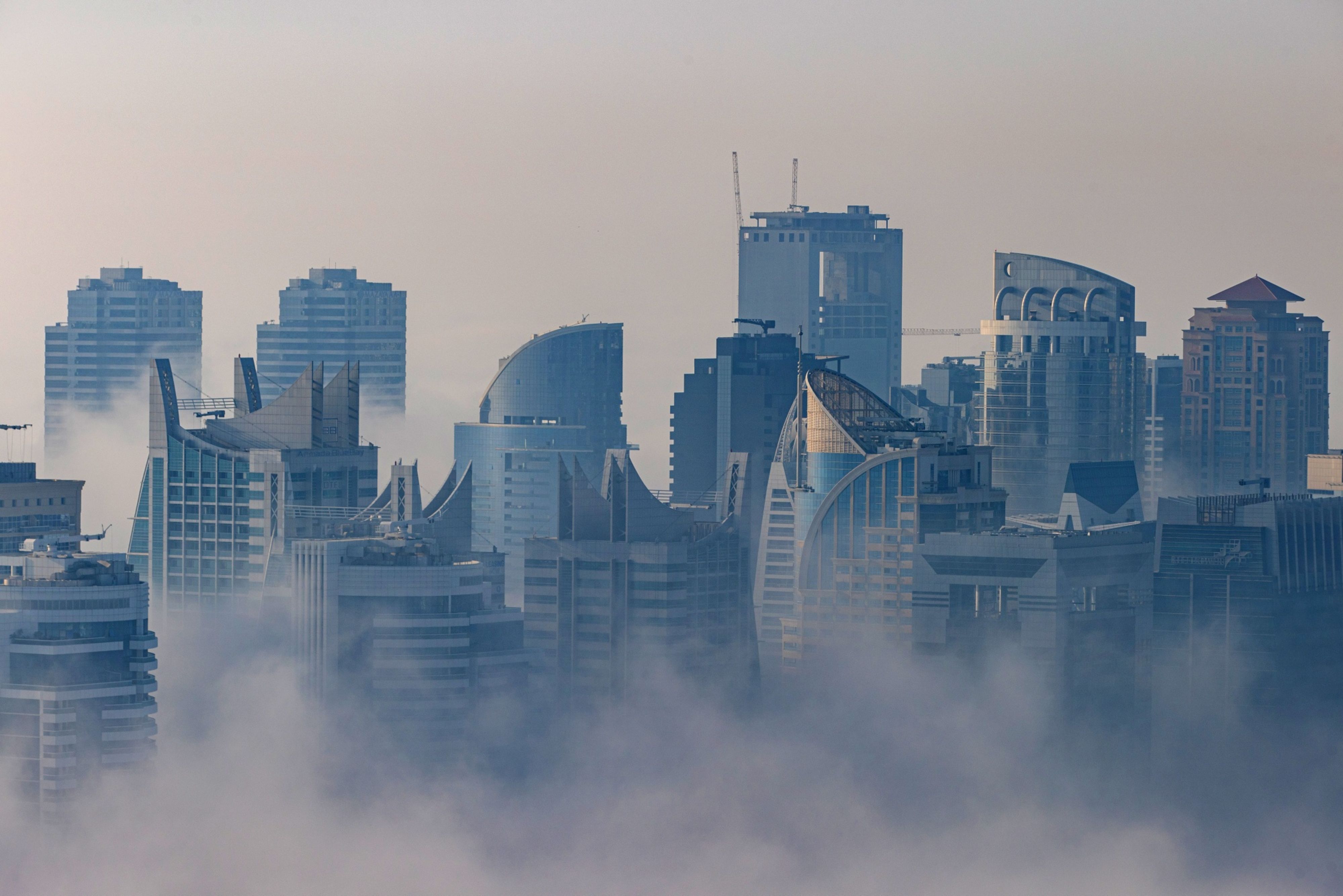 Morning fog shrouds residential and commercial skyscrapers in the Dubai Marina district of Dubai