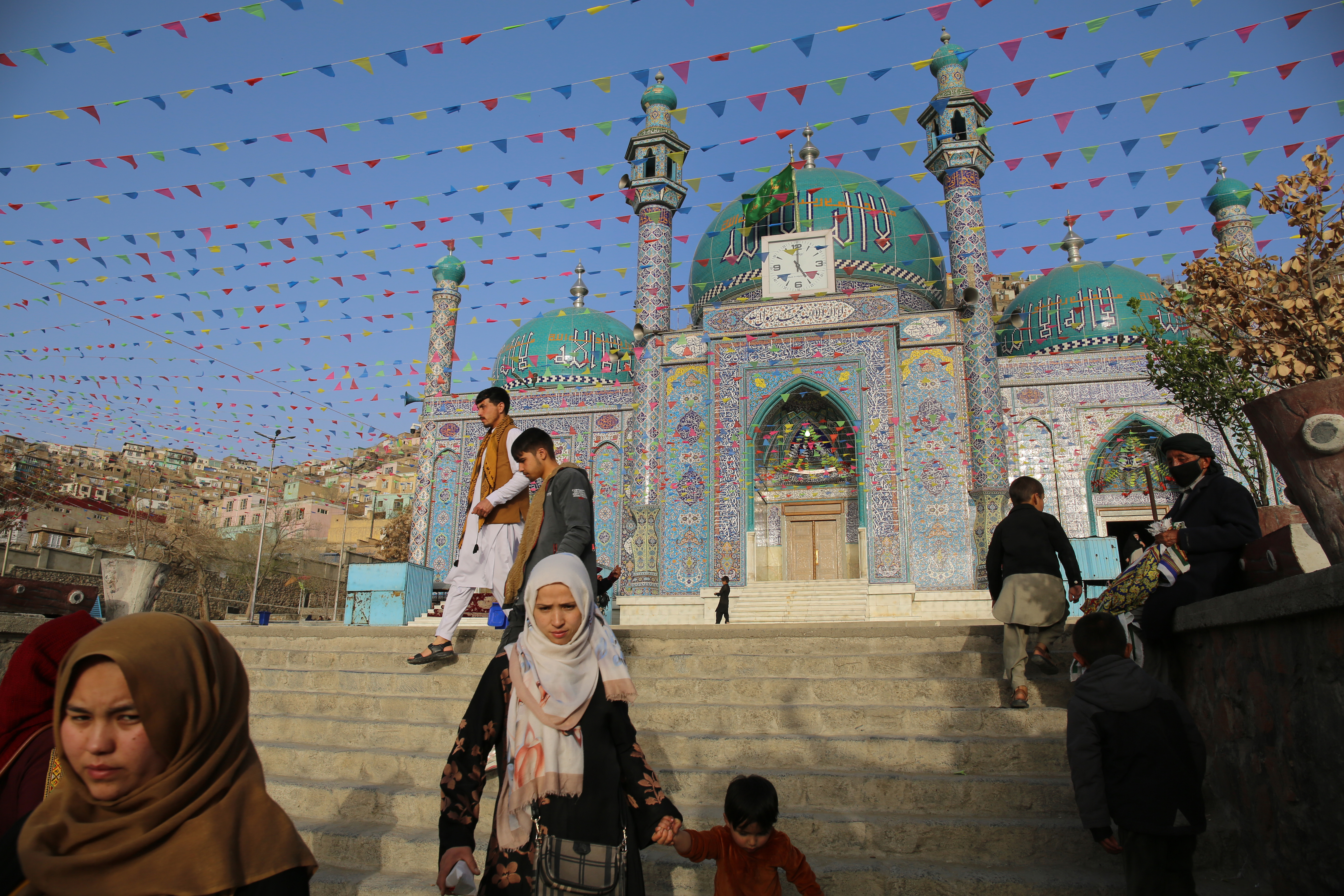 Colorful flags flutter in the spring breeze outside the Shia shrine