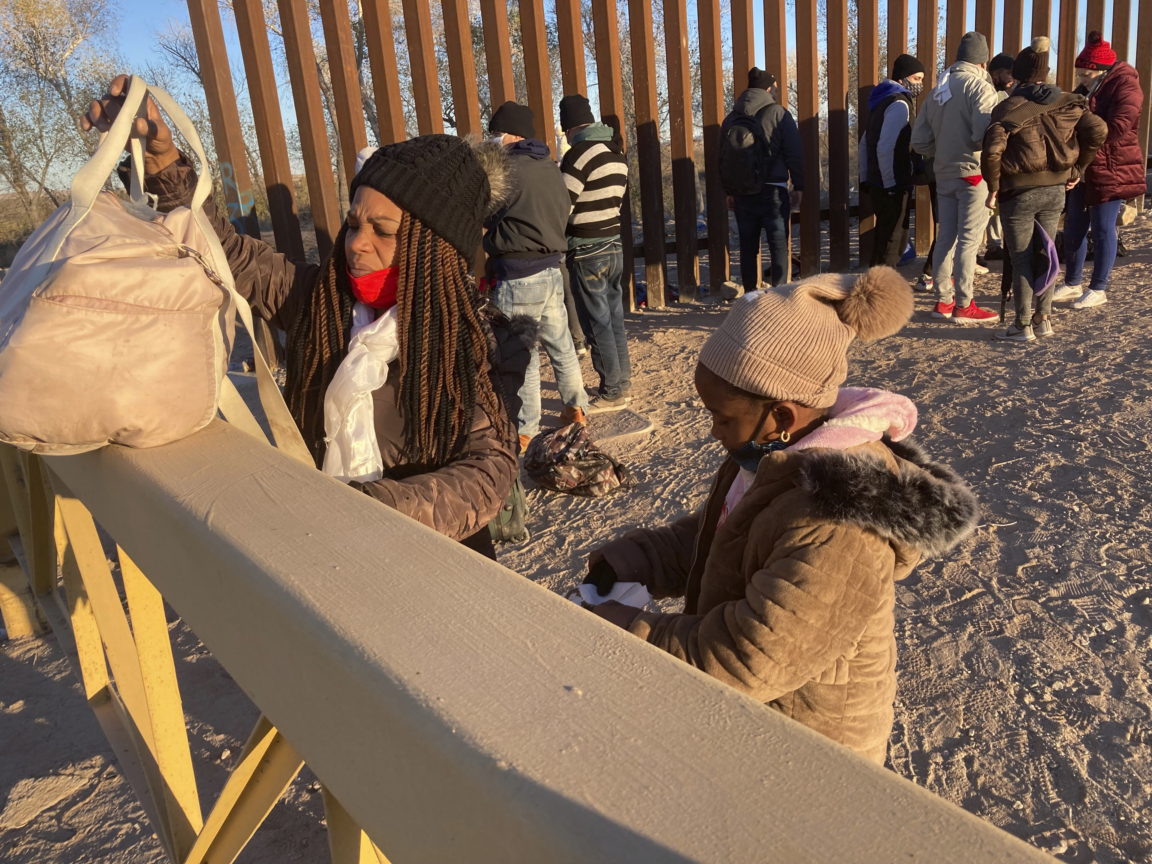A Cuban woman and her daughter wait in line to be escorted to a Border Patrol van for processing in Yuma, Arizona, the United States on February 6, 2022