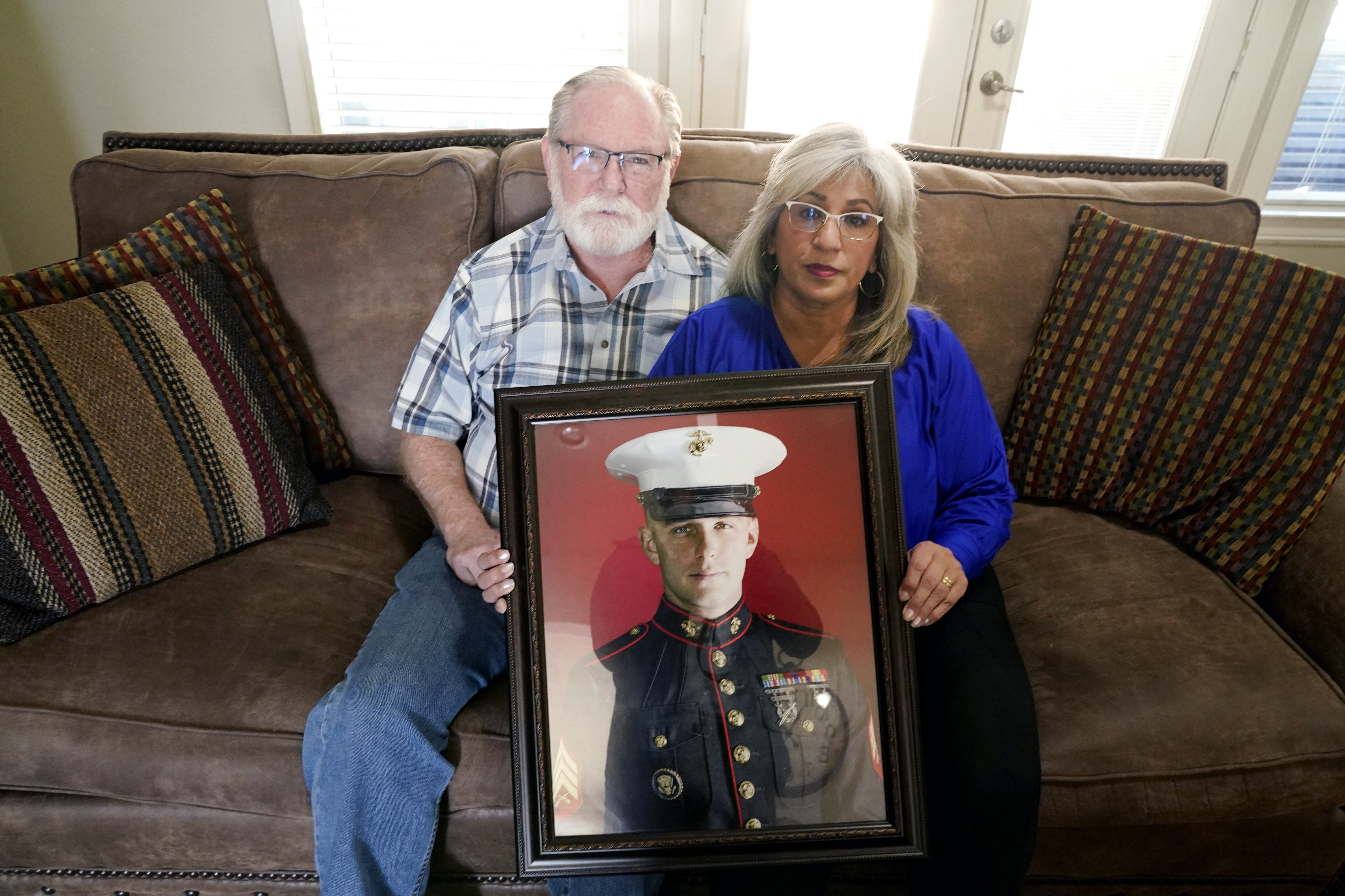 Parents of Trevor Reed hold a picture of him 