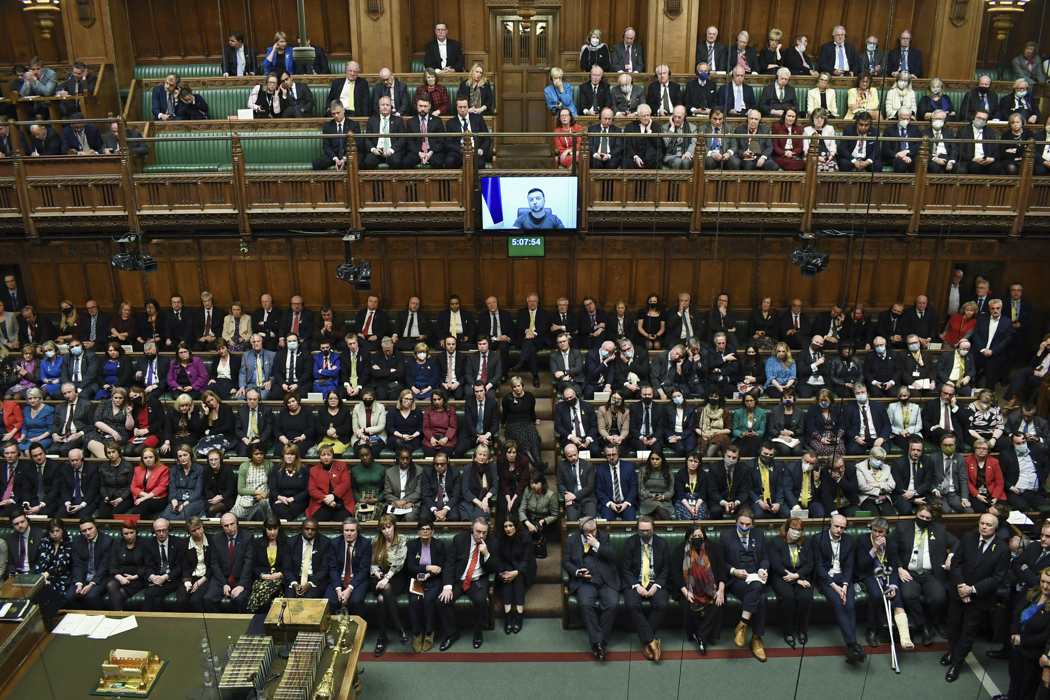 Ukrainian President Volodymyr Zelenskyy is displayed on the screen as he addresses British lawmakers. 