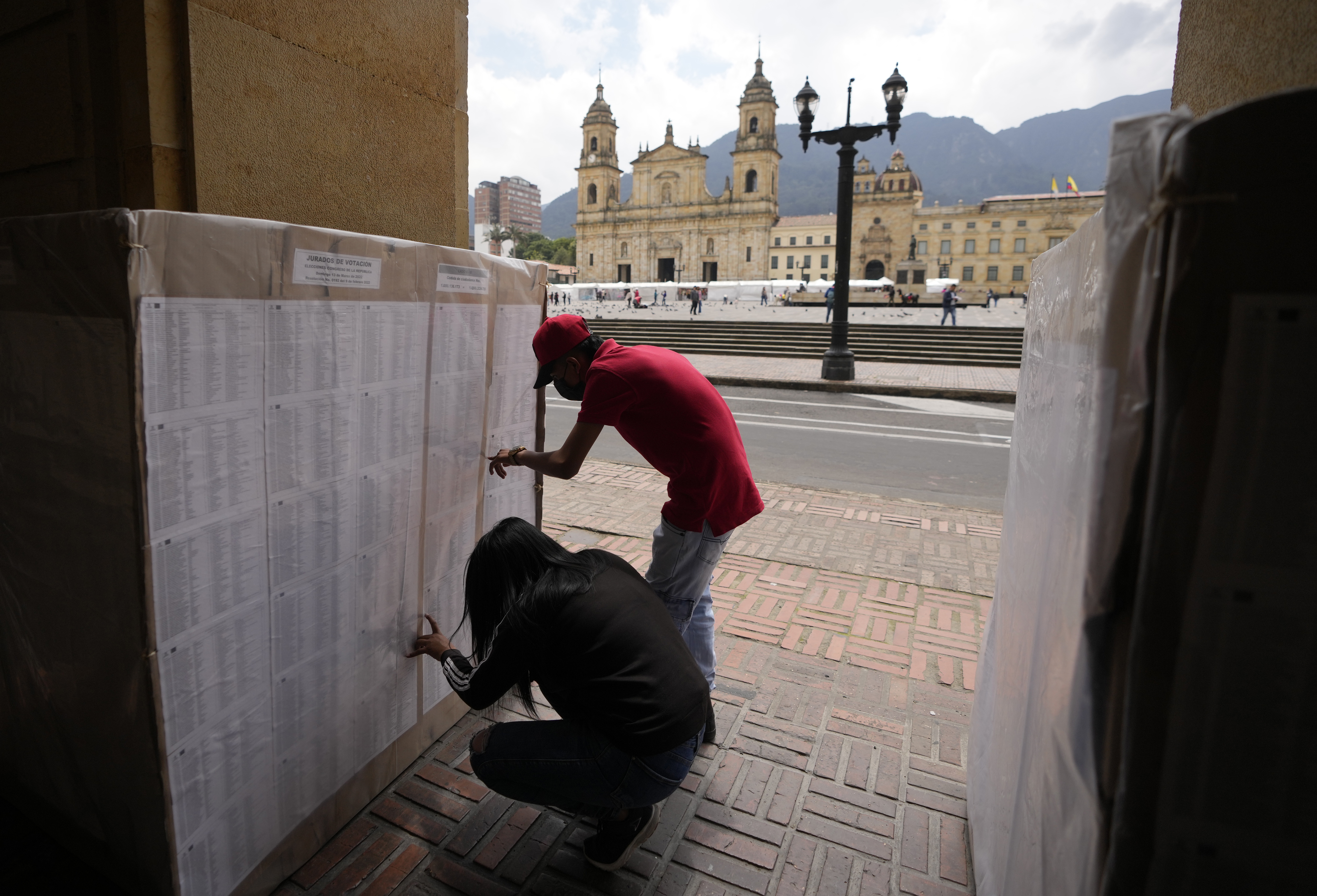 People look at a list of election workers in downtown Bogota, Colombia